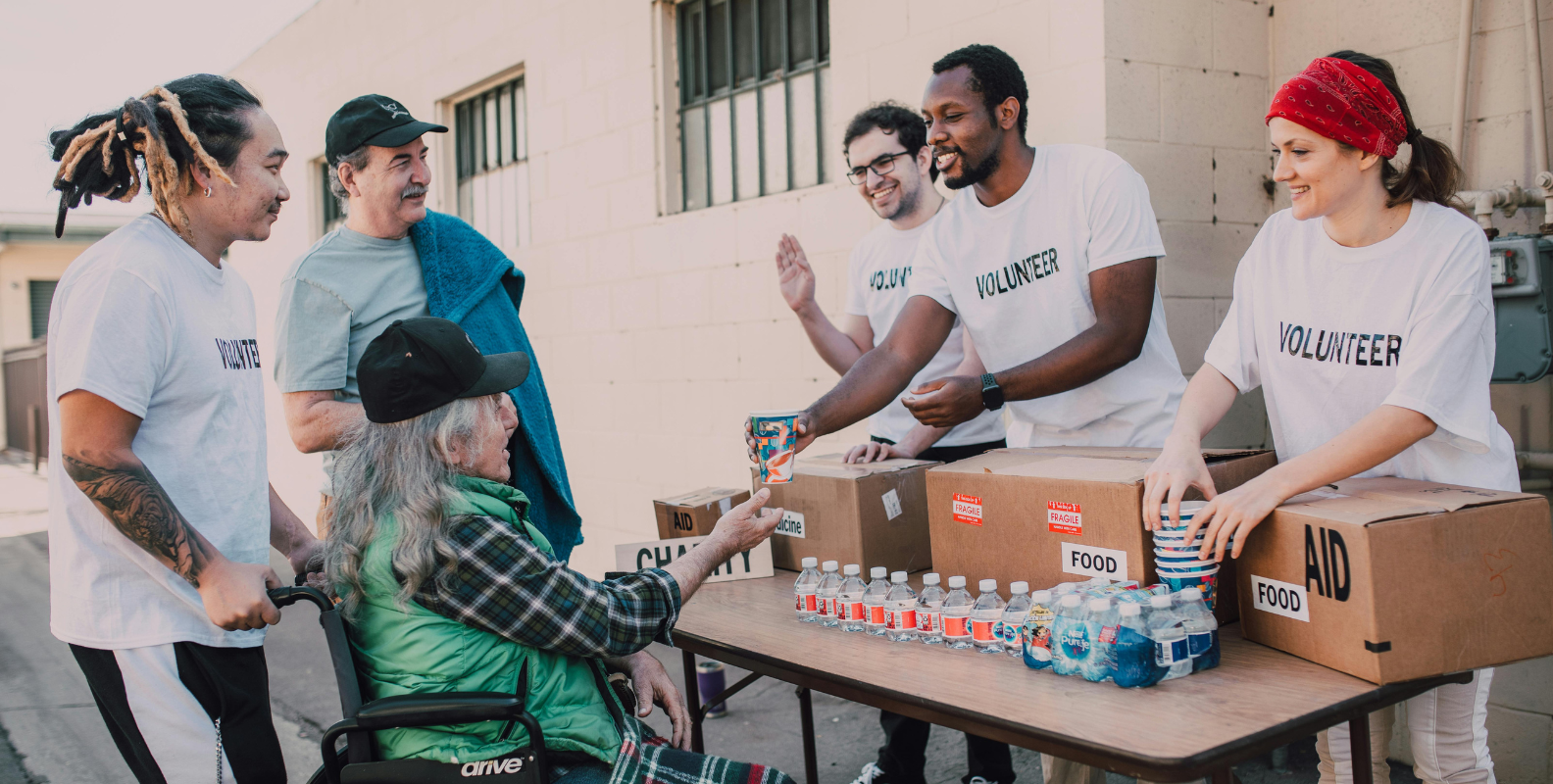 Ehrenamtliche Tätigkeit, Ausgabe von Lebensmittel an ältere Frau im Rollstuhl