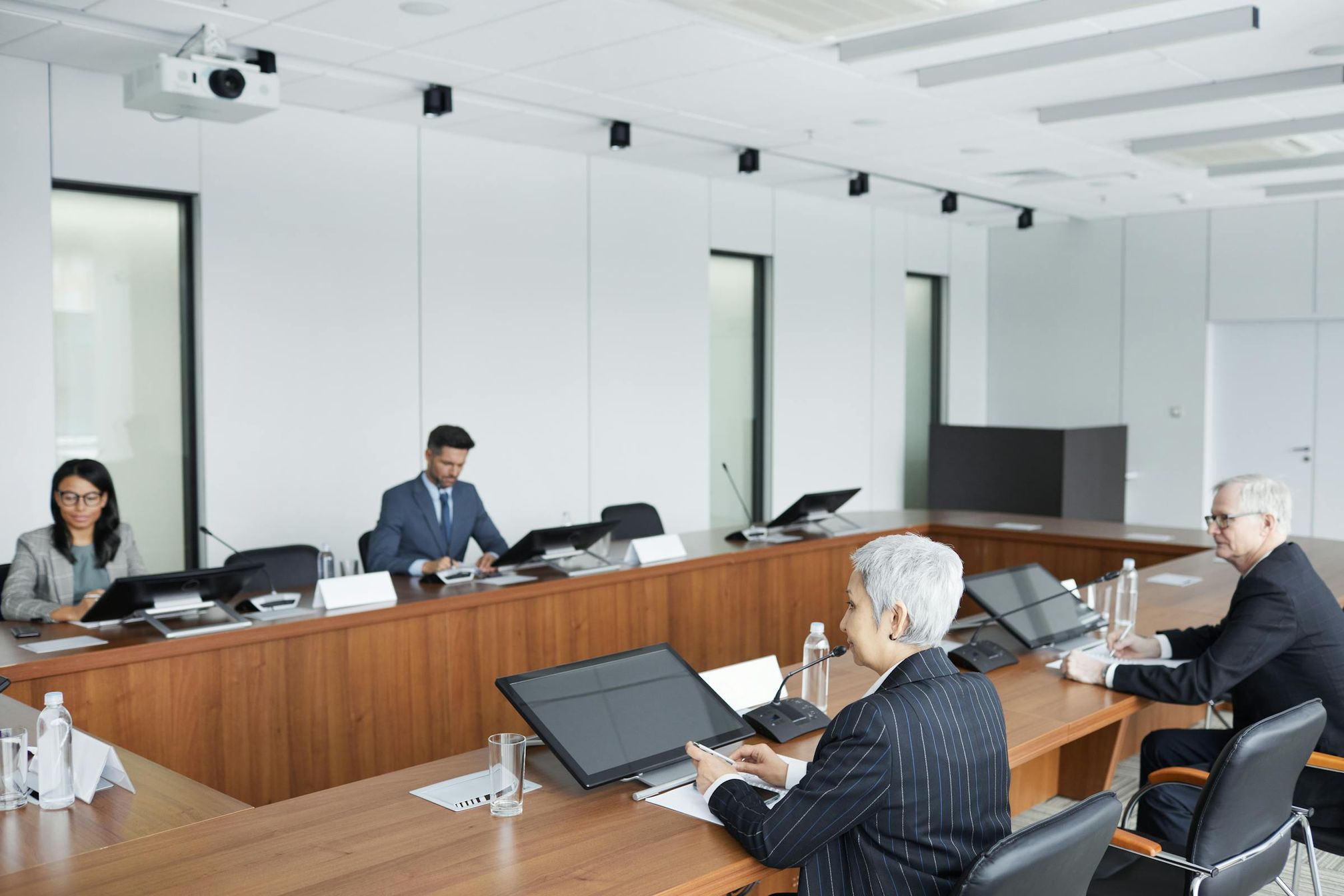 Mehrere Personen sitzen an einem Konferenztisch und nehmen an einer formellen Gremiensitzung teil – symbolisch für eine Verbandsversammlung