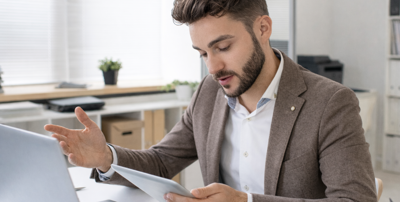 Ein Mann erklärt etwas und hält ein Tablet in der Hand