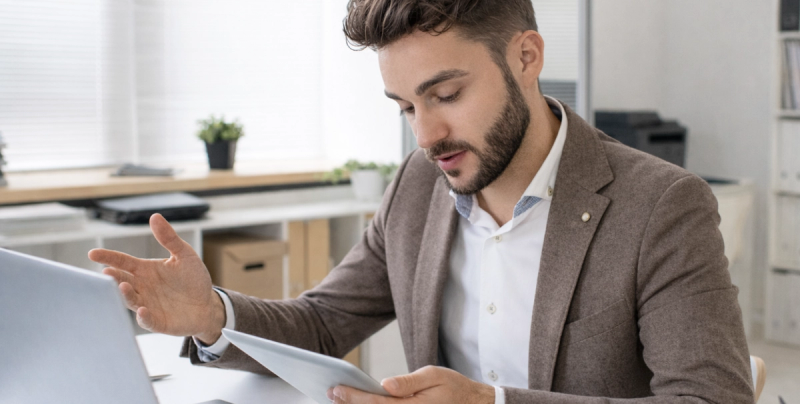 Ein Mann erklärt etwas und hält ein Tablet in der Hand