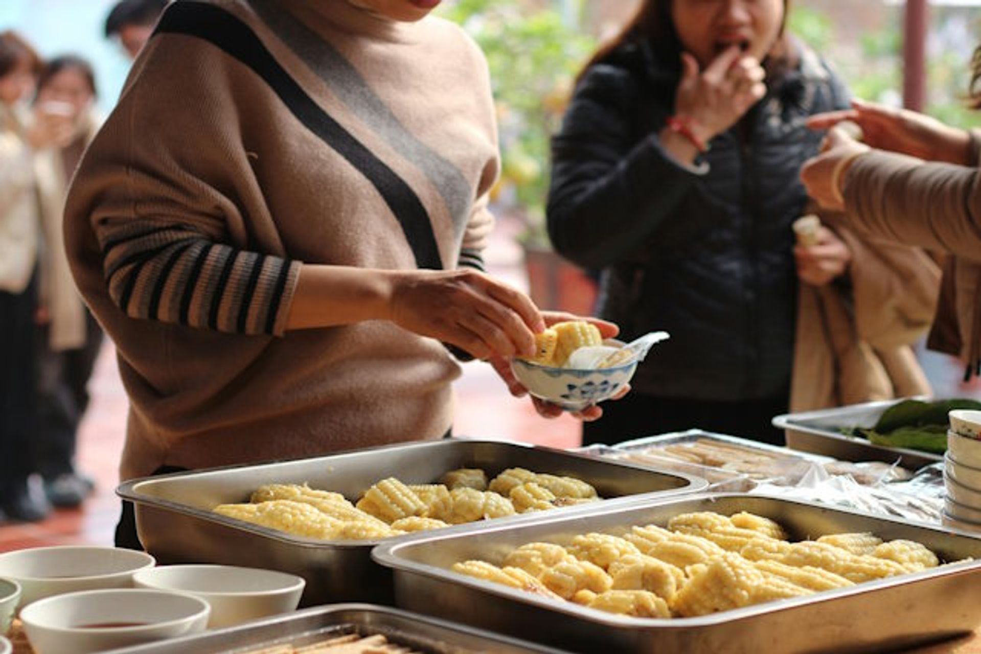 Imbissstand mit Personen die Essen in der Hand halten