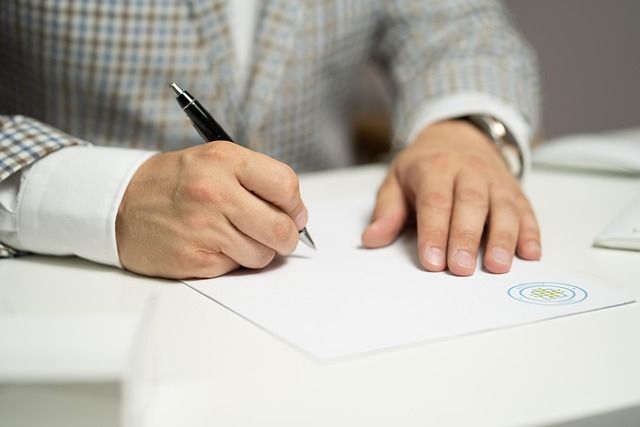 Eine Person unterschreibt ein Dokument.