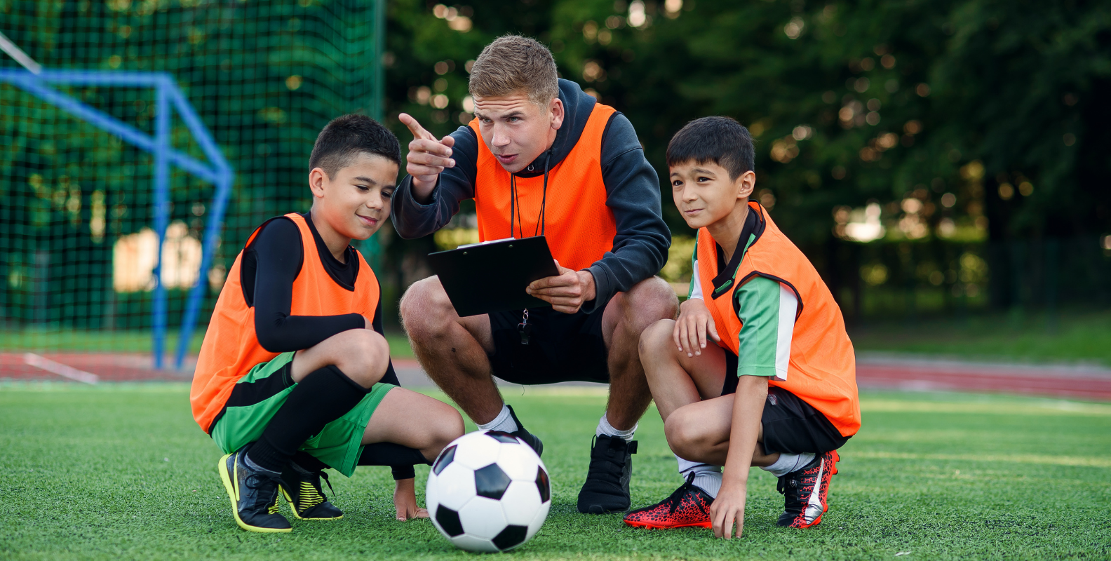Zwei Jungs mit einem Fußballtrainer
