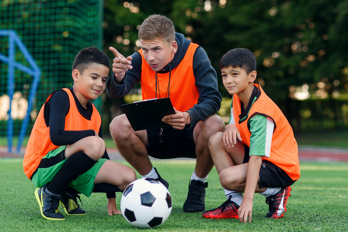 Zwei Jungs mit einem Fußballtrainer