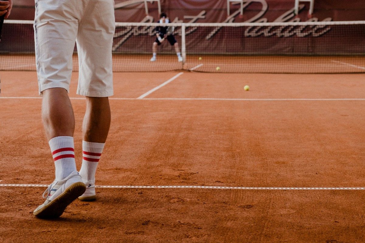Ein Mann steht auf einem Tennis-Sandplatz