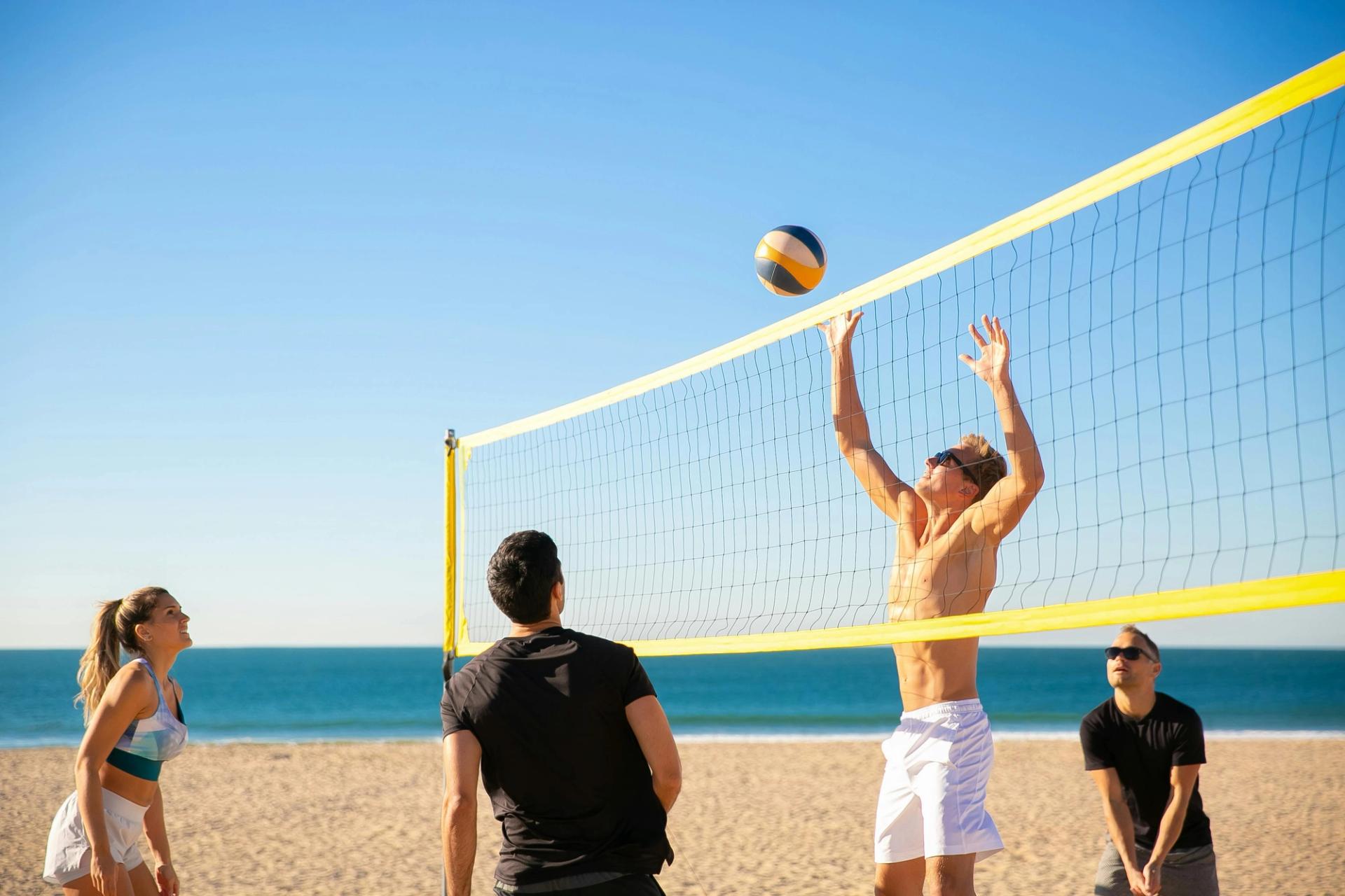 Junge Leute spielen Beachvolleyball am Strand