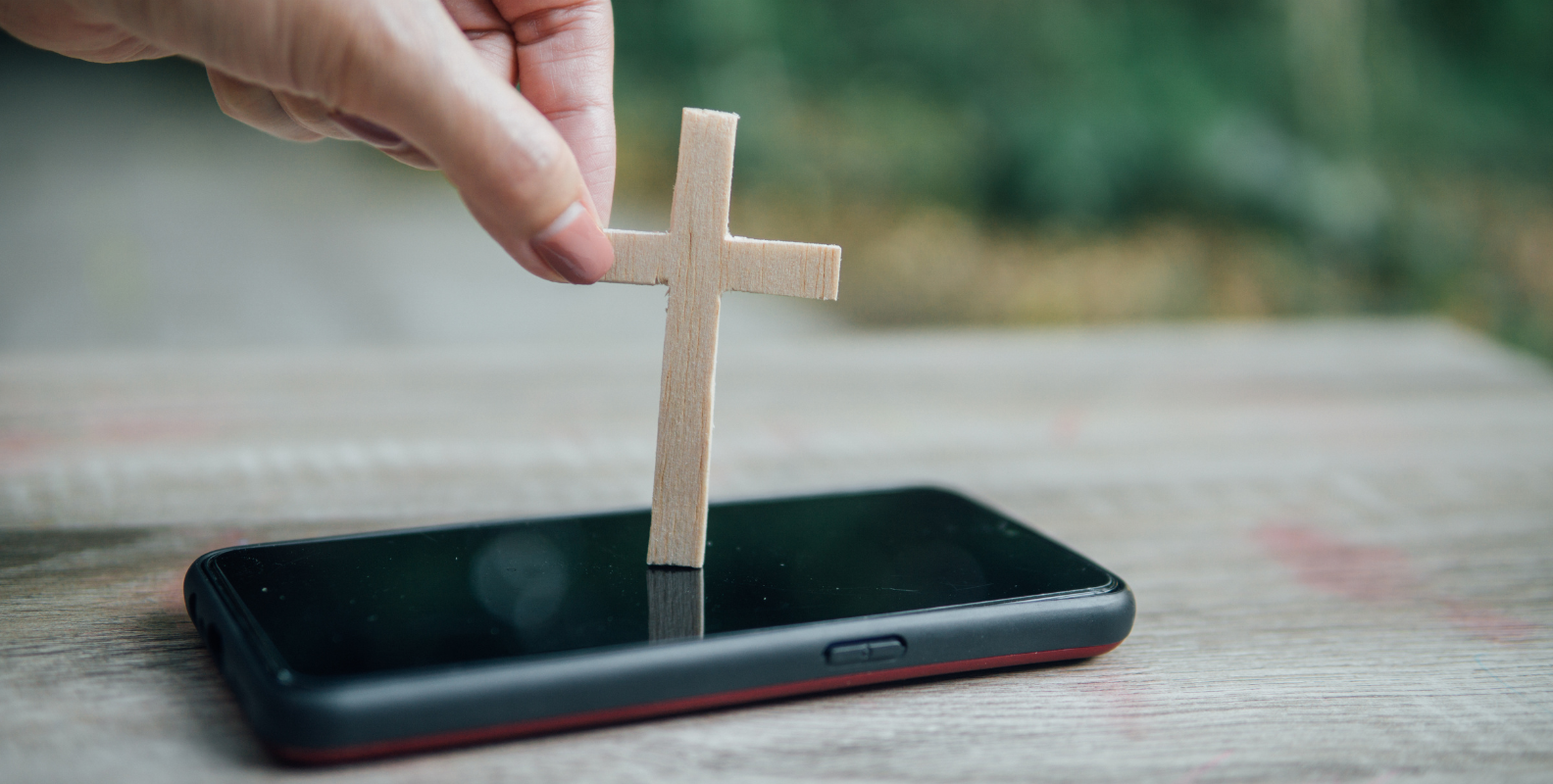 Kreuz aus Holz auf Smartphone