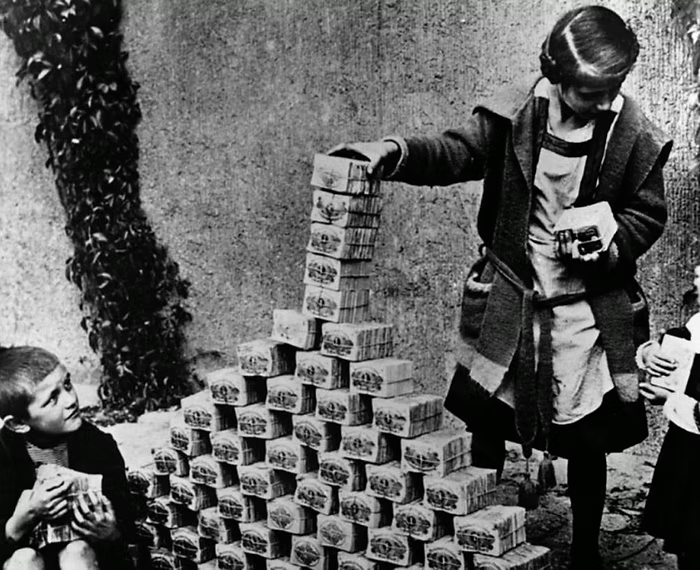 Black and white photograph showing children stacking boxes of currency during hyperinflation in Weimar Germany.