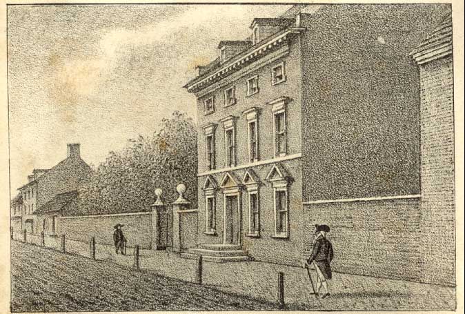 Lithograph of a three-story townhouse behind a brick wall on a city street, with a man walking past with a cane