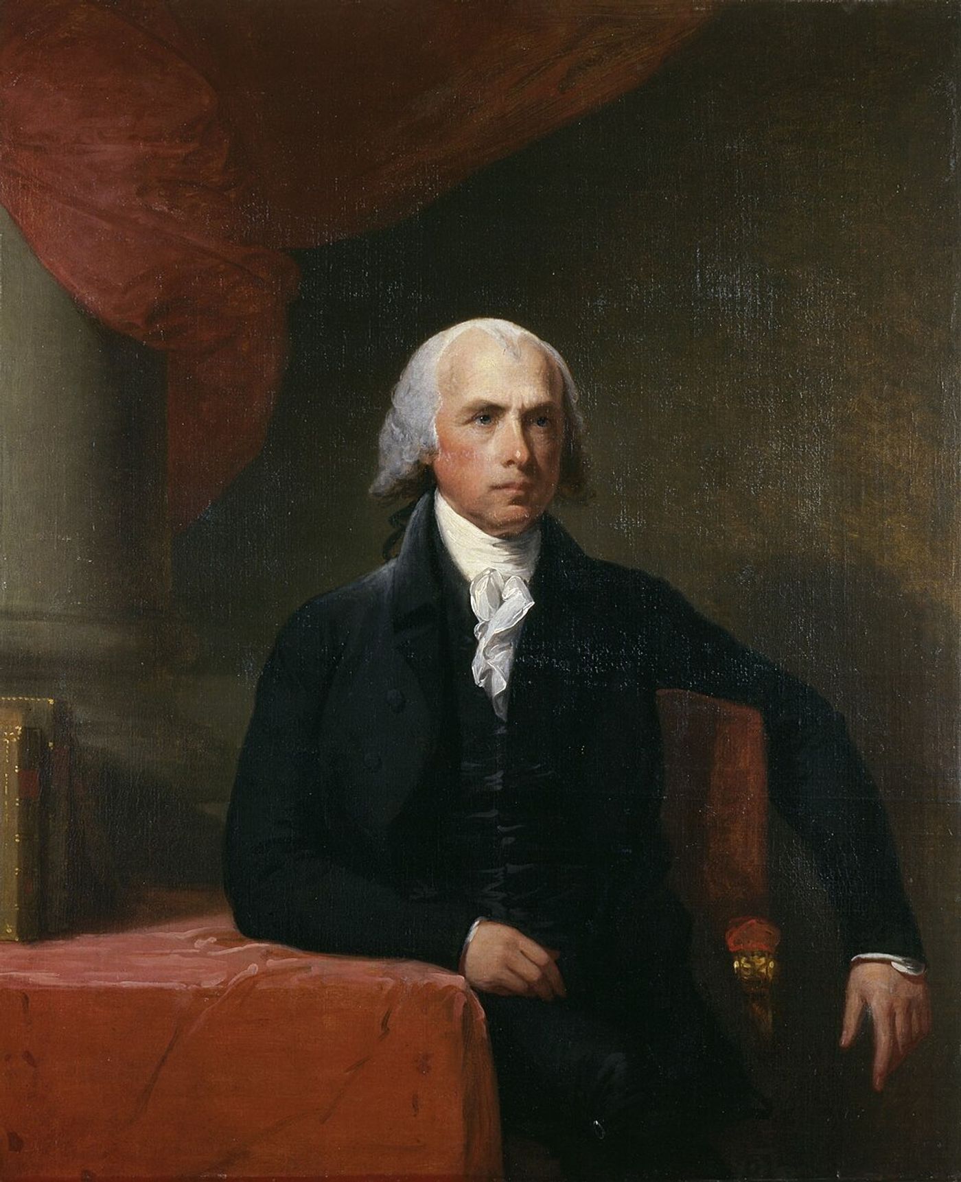Portrait of an elderly man with white hair wearing a dark coat and white cravat, seated at a table with red fabric.