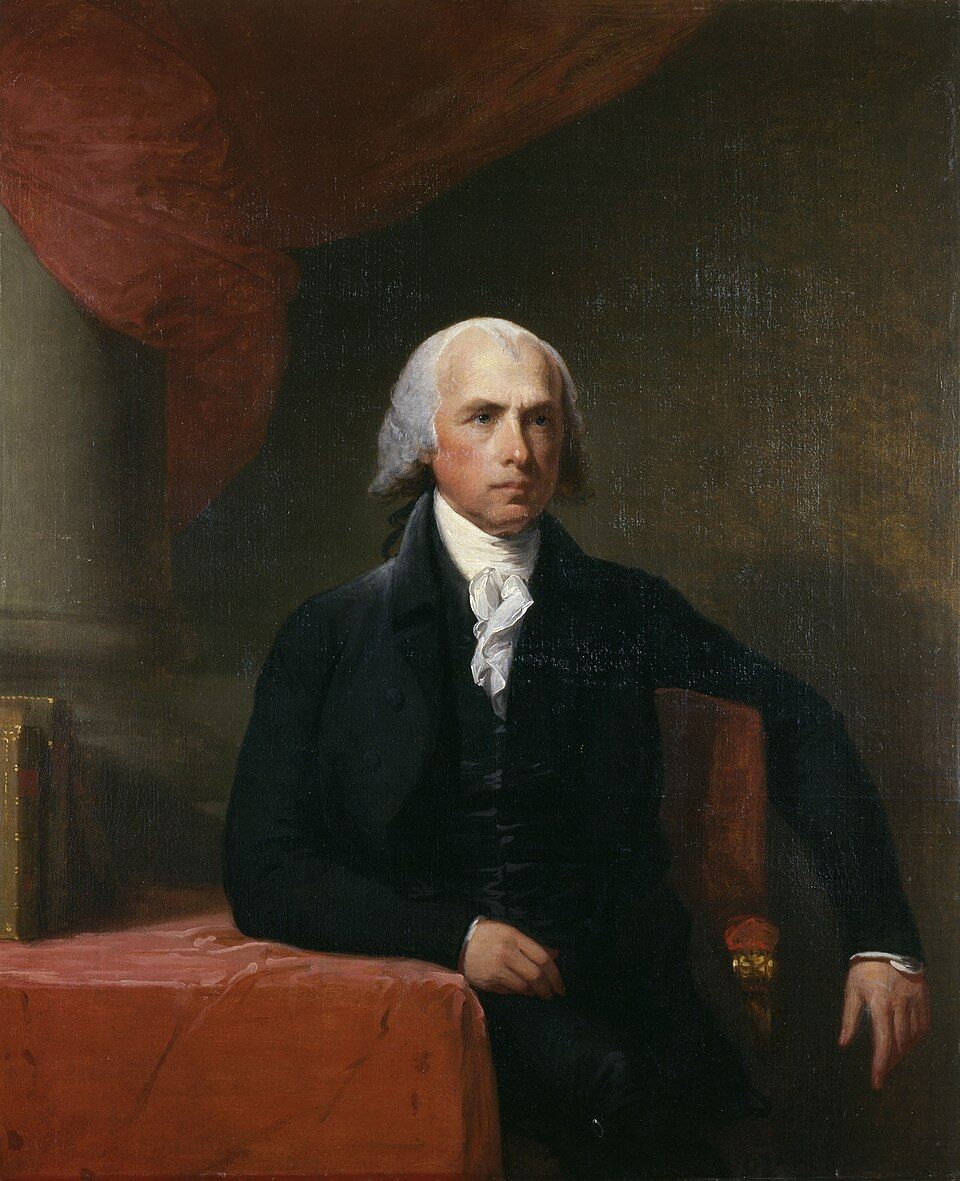 Portrait of an elderly man with white hair wearing a dark coat and white cravat, seated at a table with red fabric.
