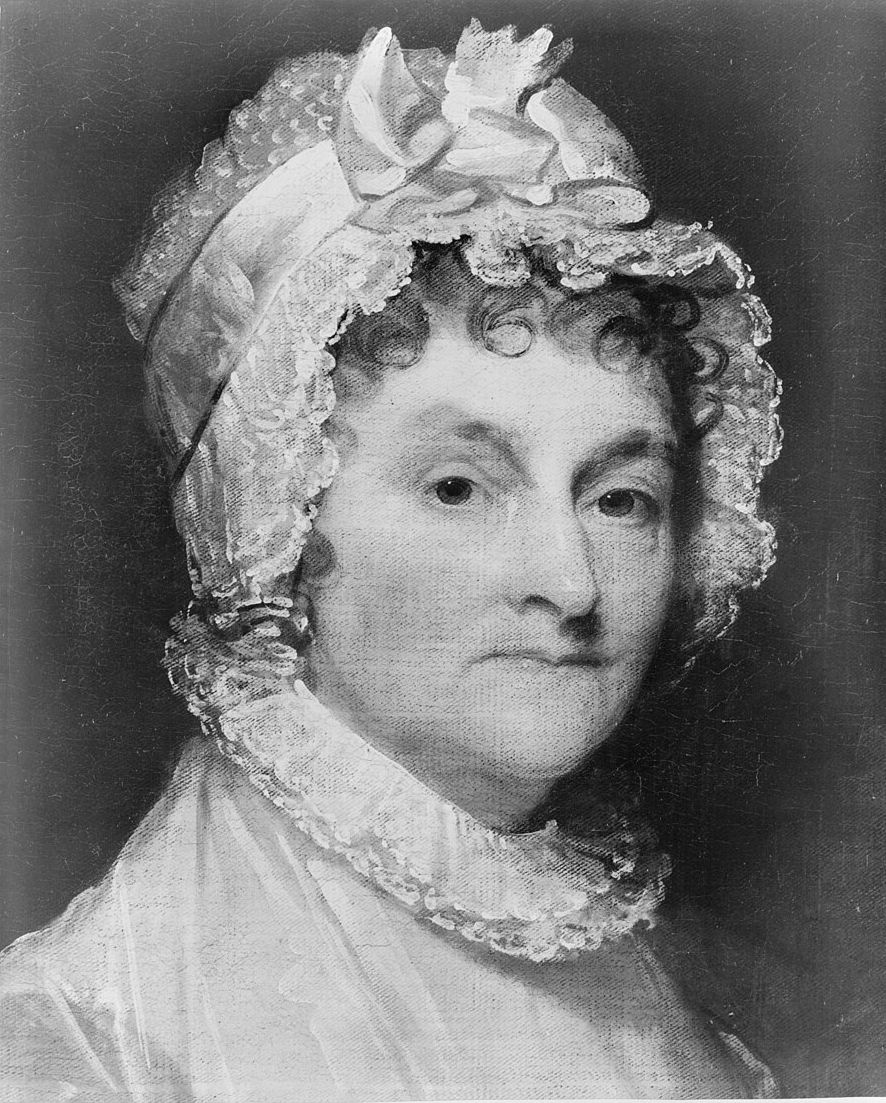 Black and white portrait of a woman wearing an elaborate white lace bonnet and high-necked dress with lace collar, circa early 1800s.