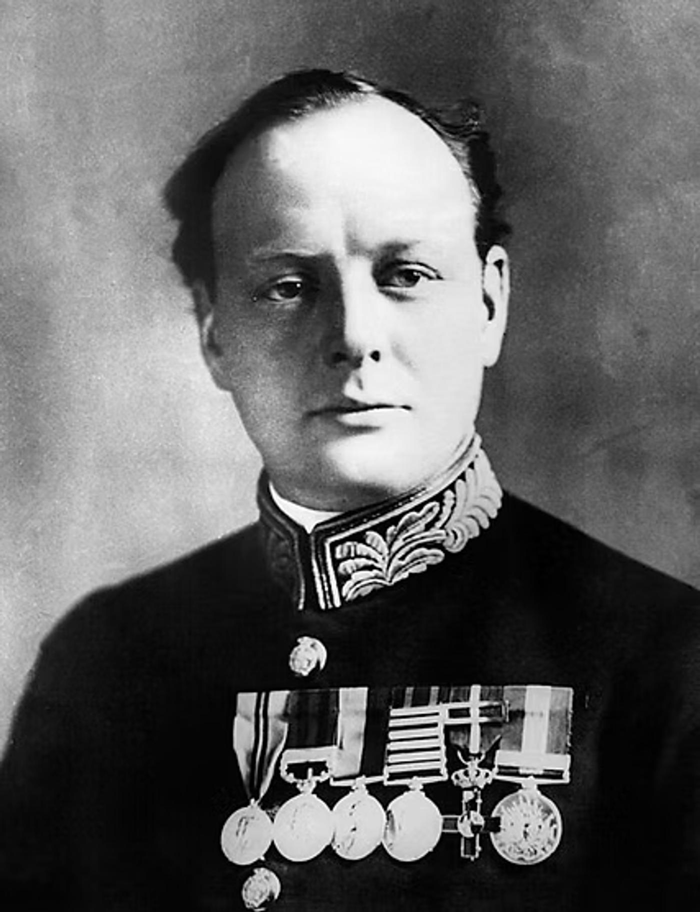 Military officer in formal dress uniform with ornate collar and multiple medals and ribbons on chest.