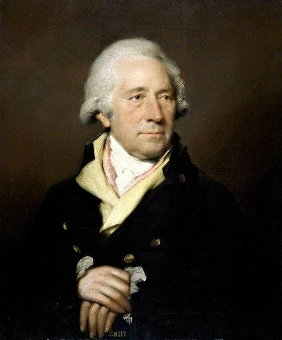 Oil portrait of Matthew Boulton in old age against a plain brown ground, in a dark coat over a pale yellow waistcoat with a white stock, his hands clasped in front of him