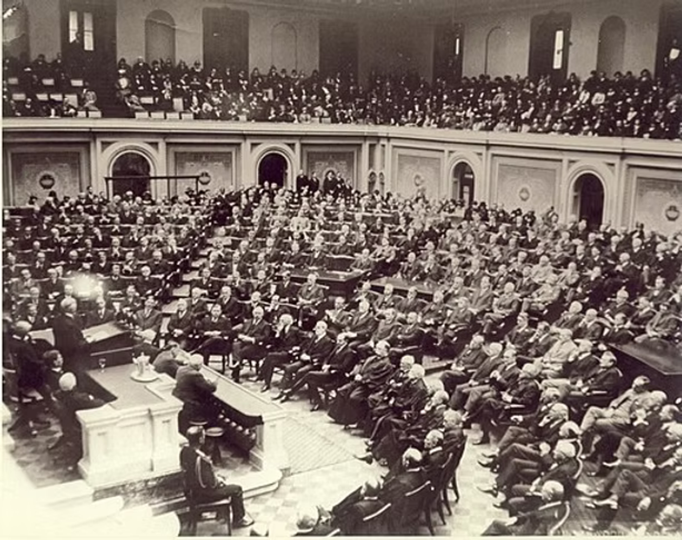 Historical photograph of a large legislative chamber filled with seated officials and spectators in a formal government assembly hall.