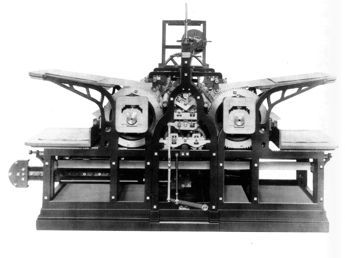 Black-and-white image of a long iron printing machine with a feeding board at each end and two large impression cylinders in the middle, linked by gears