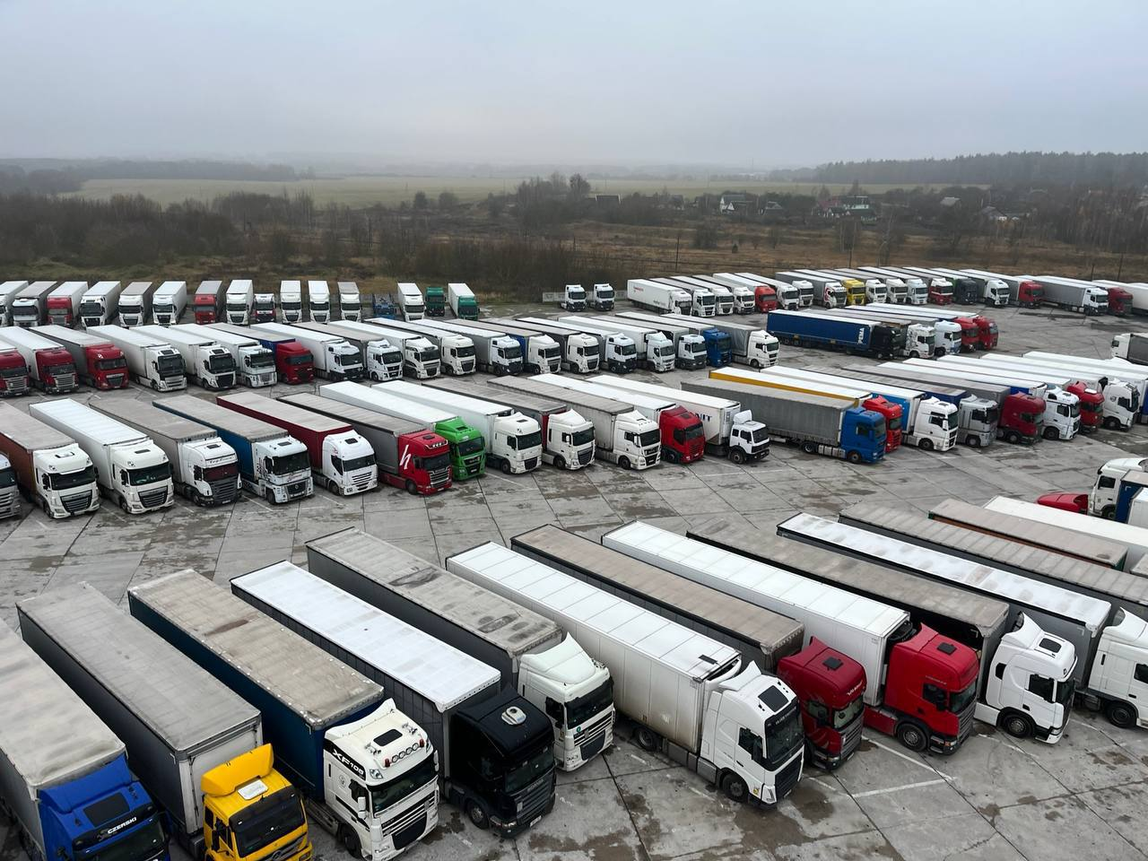 Lithuanian trucks parked in guarded parking lots at checkpoints on the Belarus-Lithuania border.