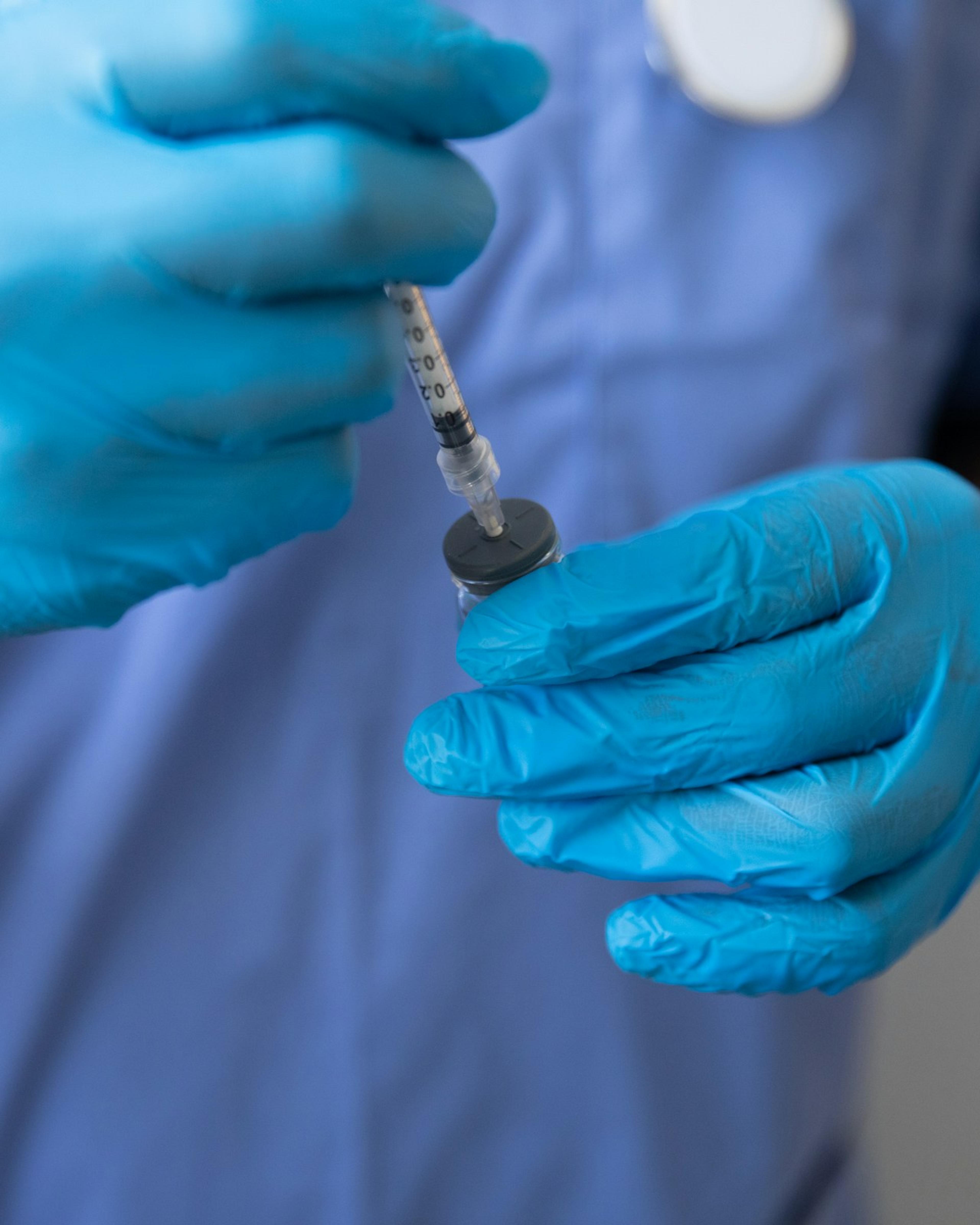Gloved hands drawing medicine into a syringe, the sharps work behind needlestick claims a healthcare worker injury attorney handles