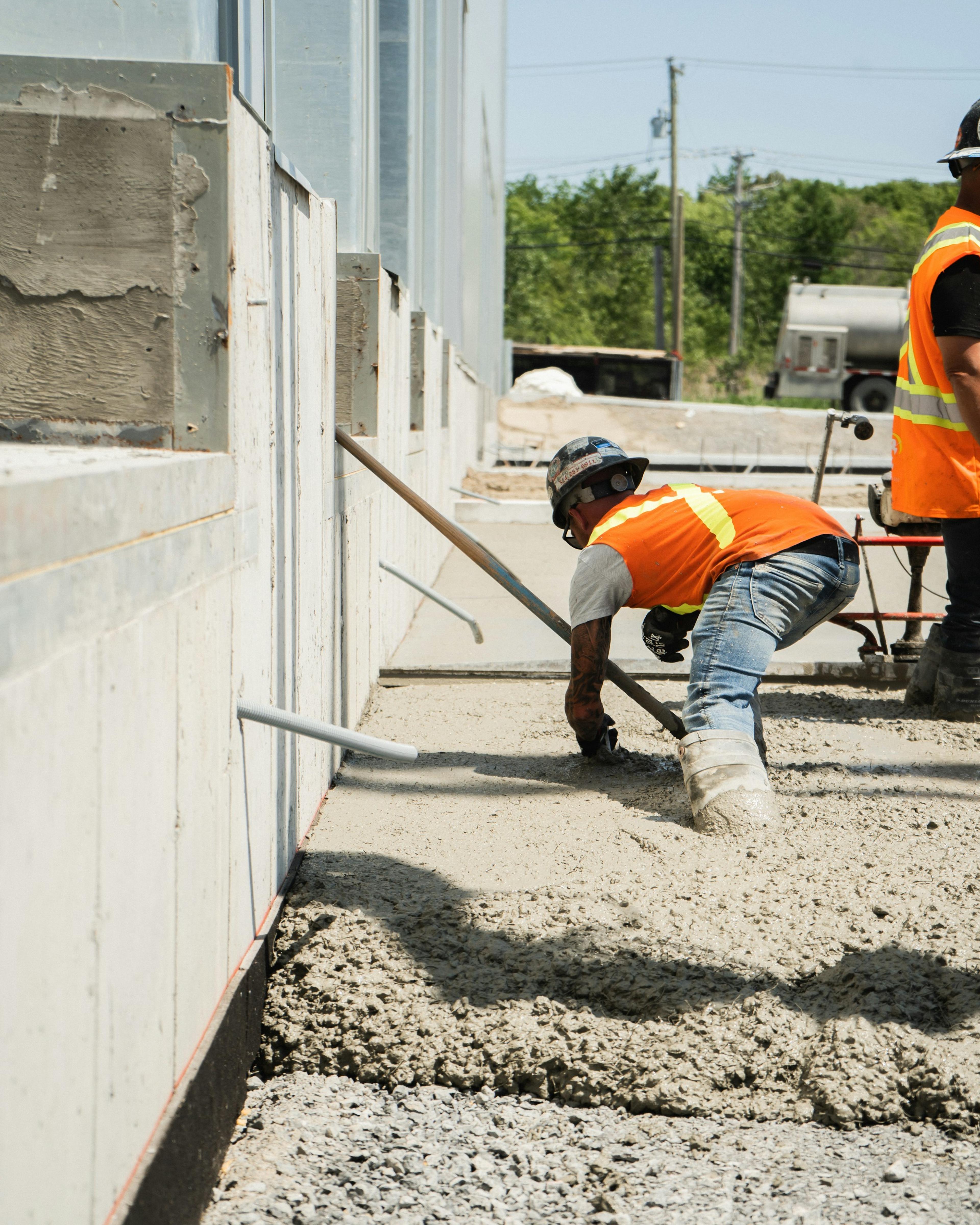 Concrete worker crouching low to spread a fresh pour, the squatting and kneeling that can lead to a meniscus tear