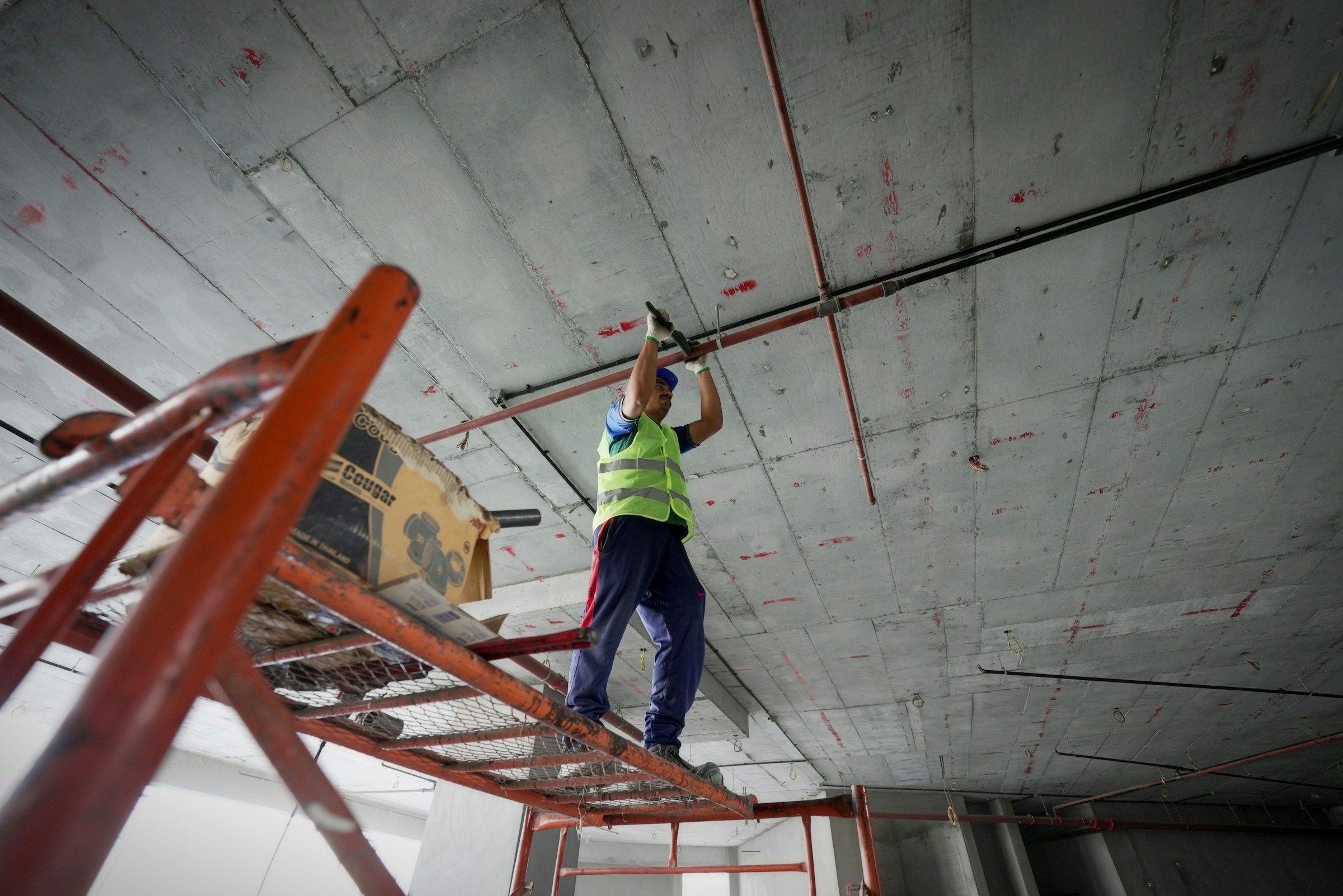 Trabajador con chaleco de seguridad en una plataforma elevada, el tipo de trabajo en altura detrás de muchas caídas en el trabajo
