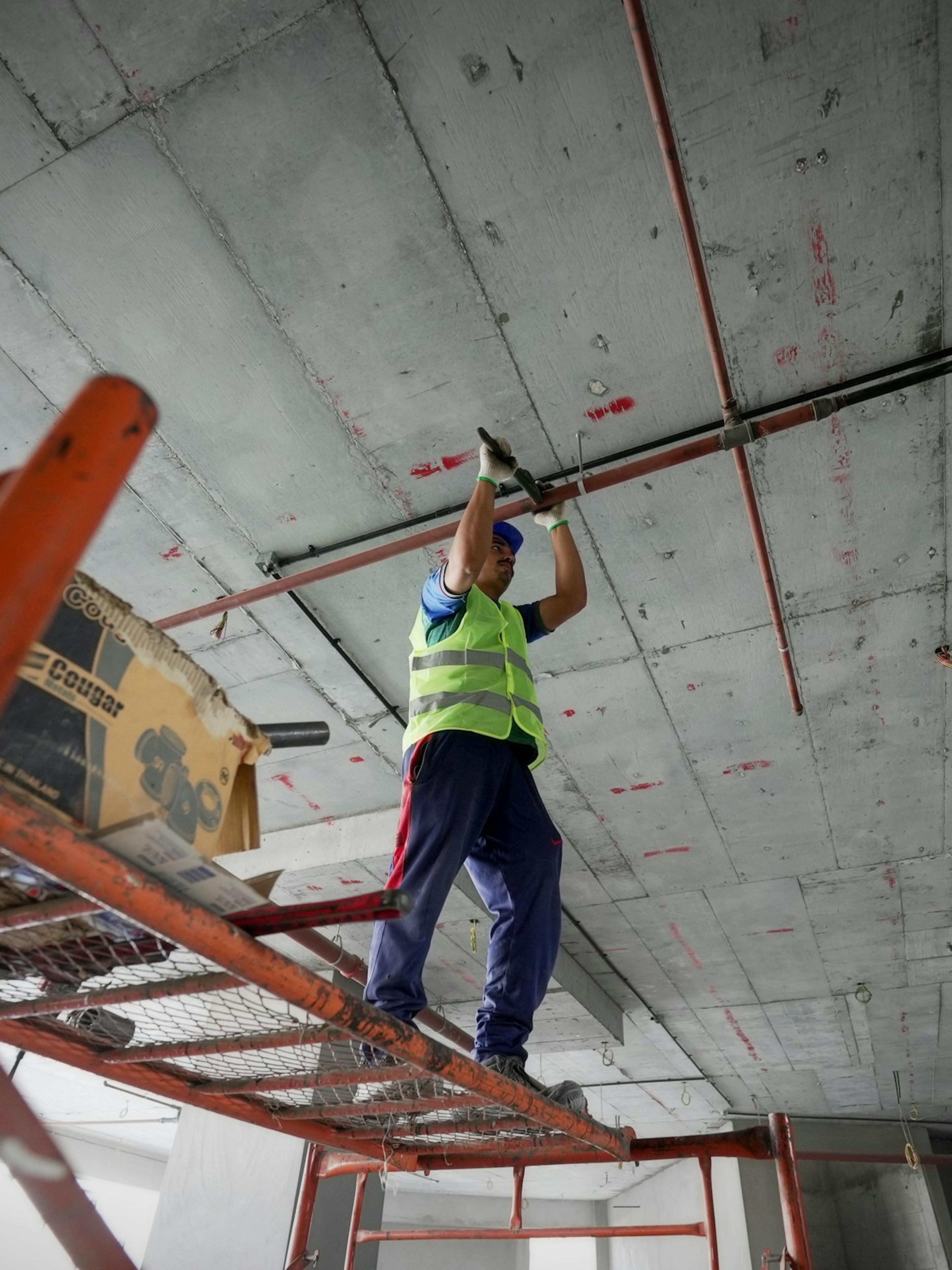 Trabajador con chaleco de seguridad en una plataforma elevada, el tipo de trabajo en altura detrás de muchas caídas en el trabajo