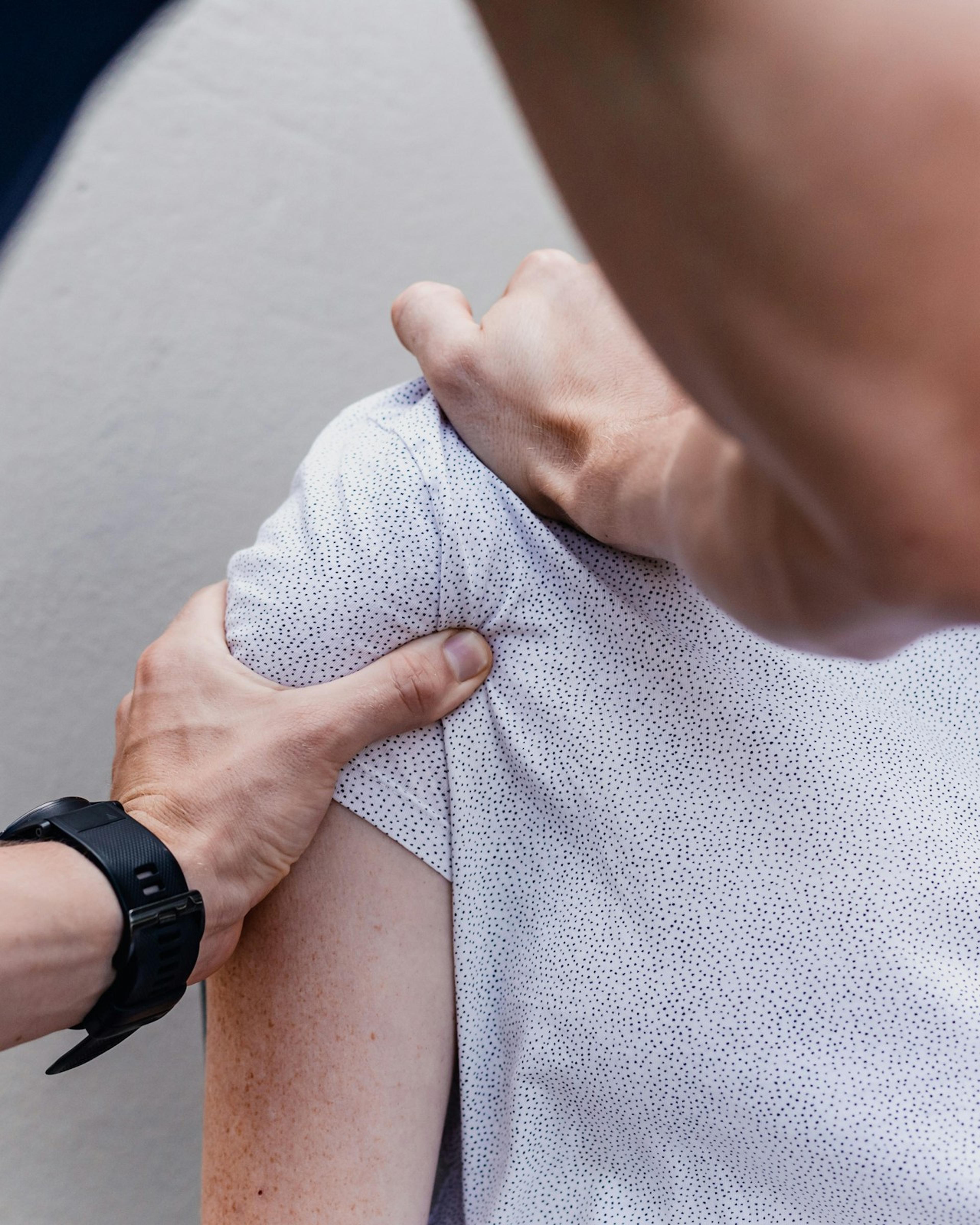 Physical therapist working on a patient’s shoulder, care workers’ comp can cover after a rotator cuff tear