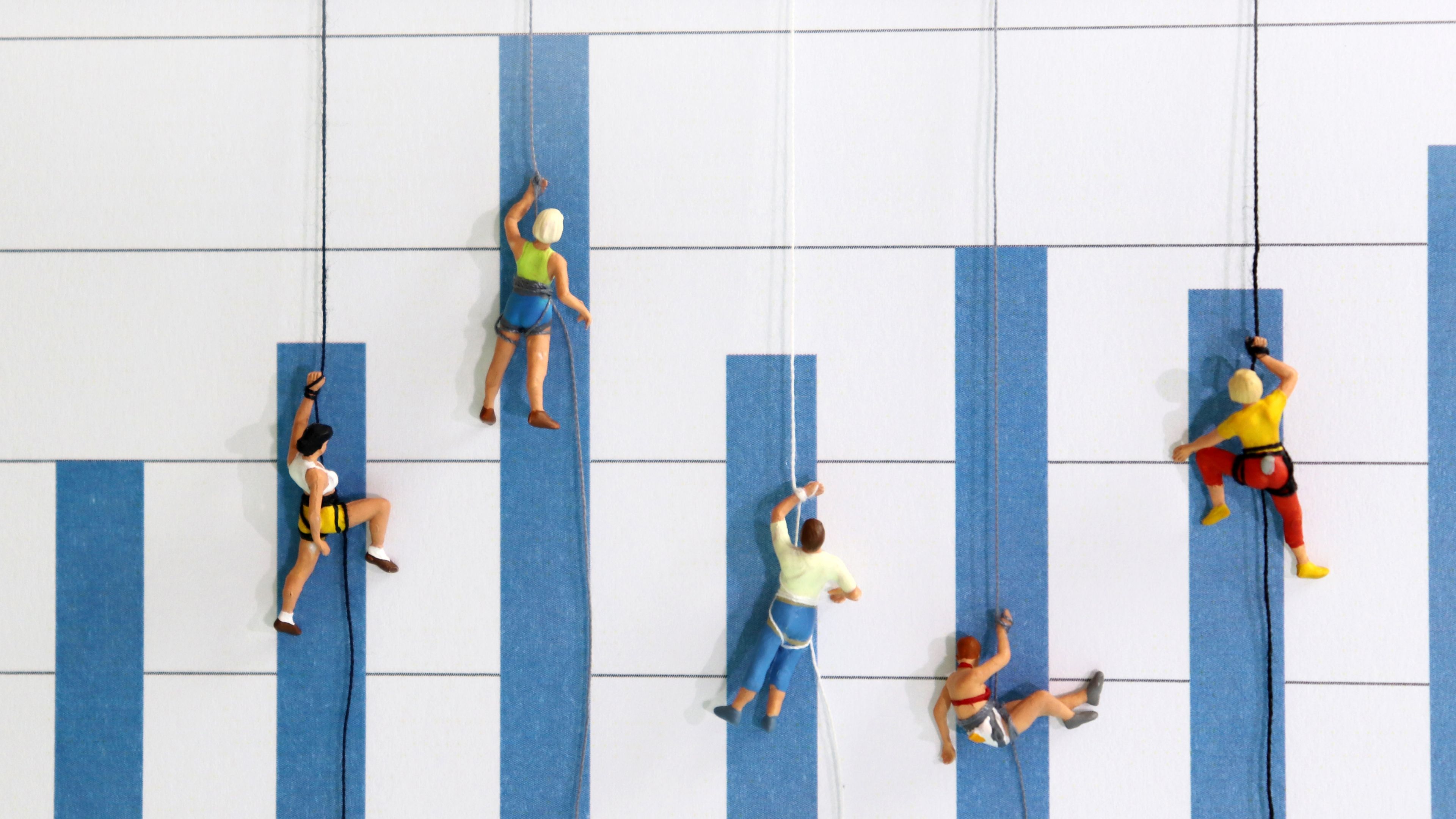 Models of people climbing a wall, but the wall is a bar chart