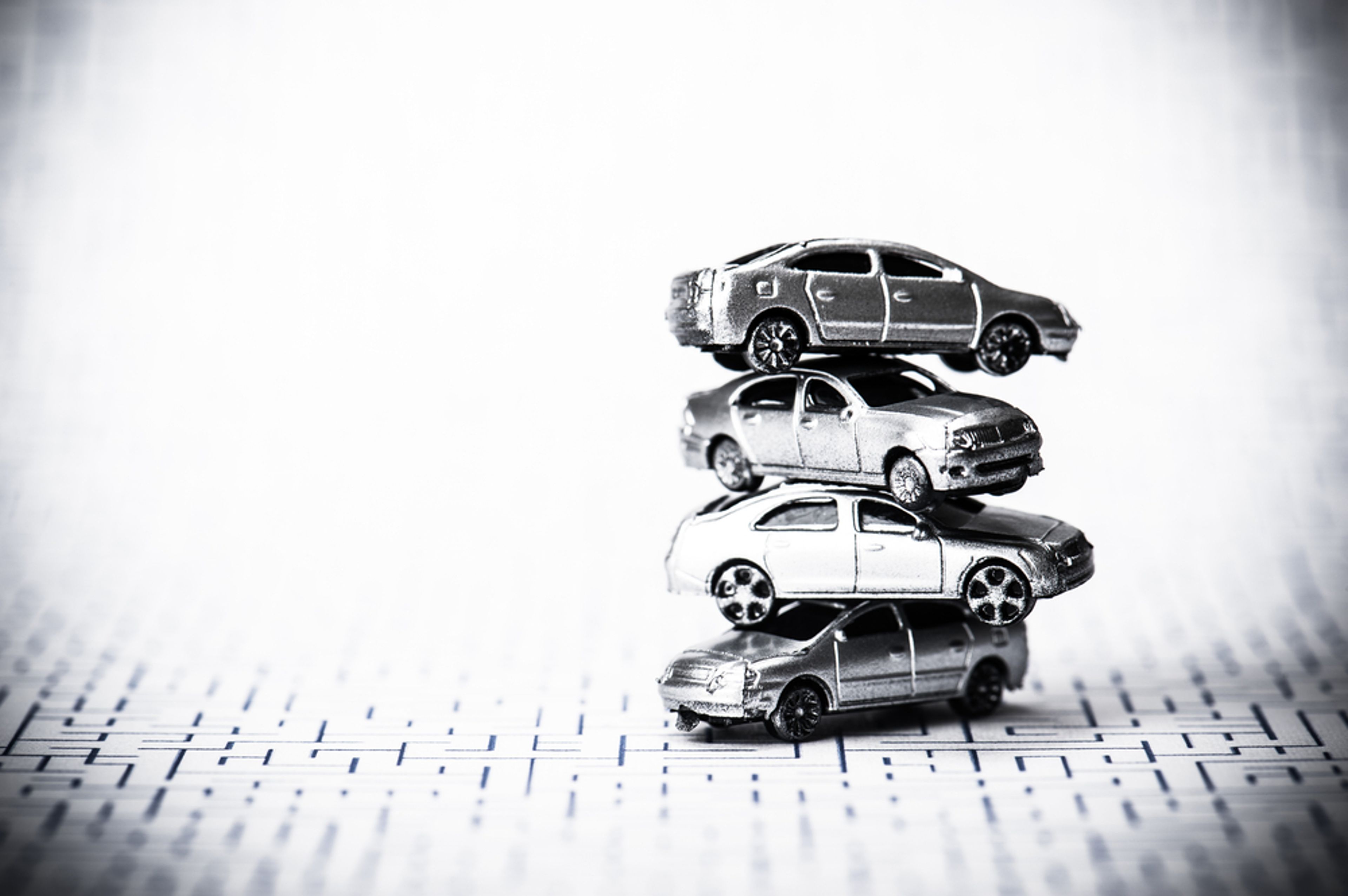 A photo of four toy cars stacked on top of one another