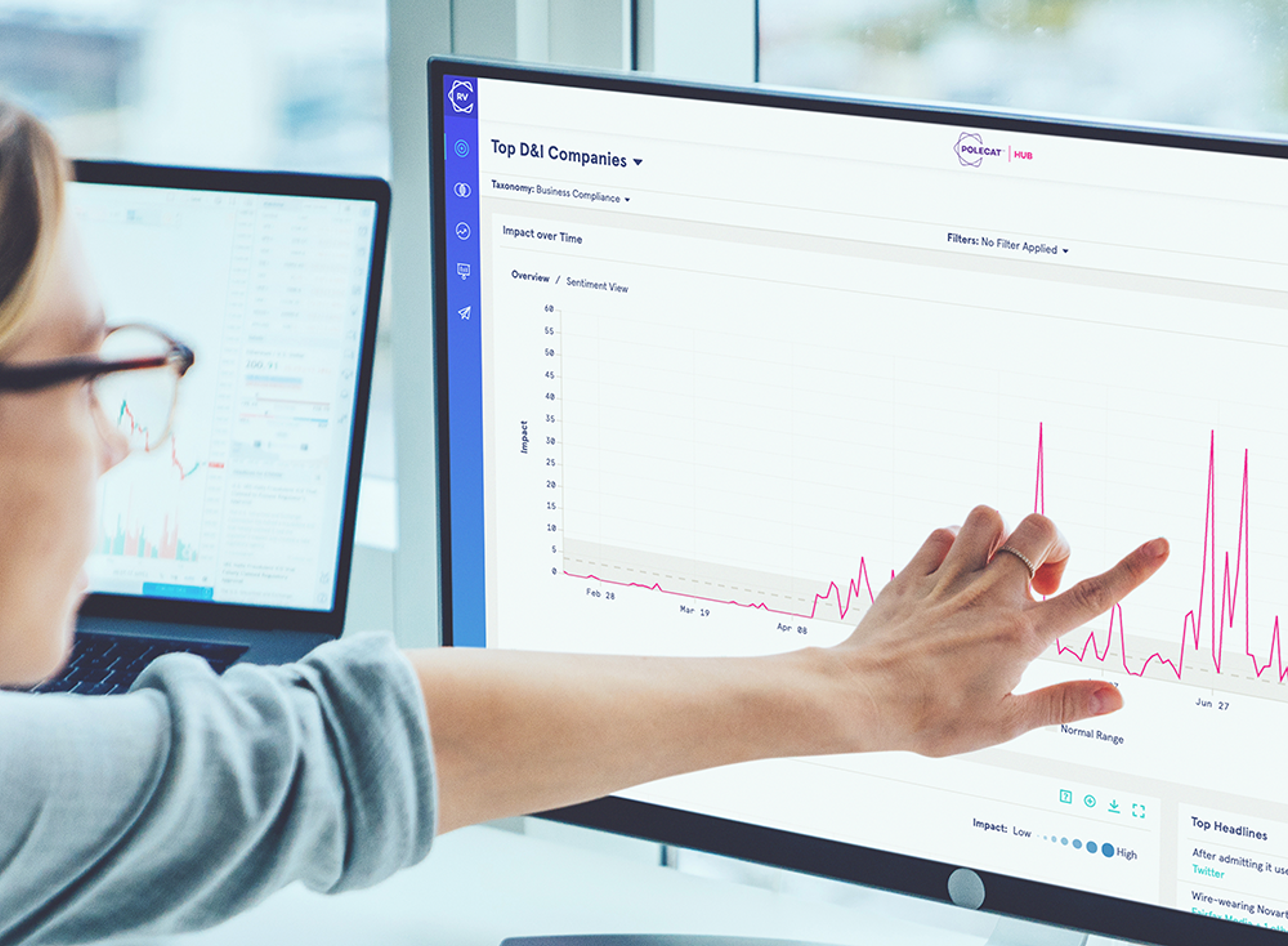 A photo of a person looking at RepVault on a computer, pointing to a chart on the screen