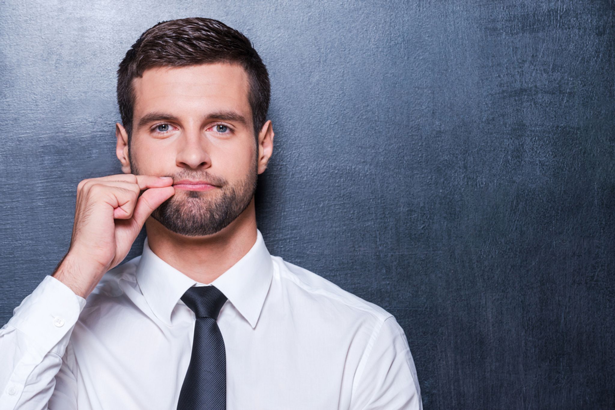 A photo of a person holding their lips shut to indicate silence