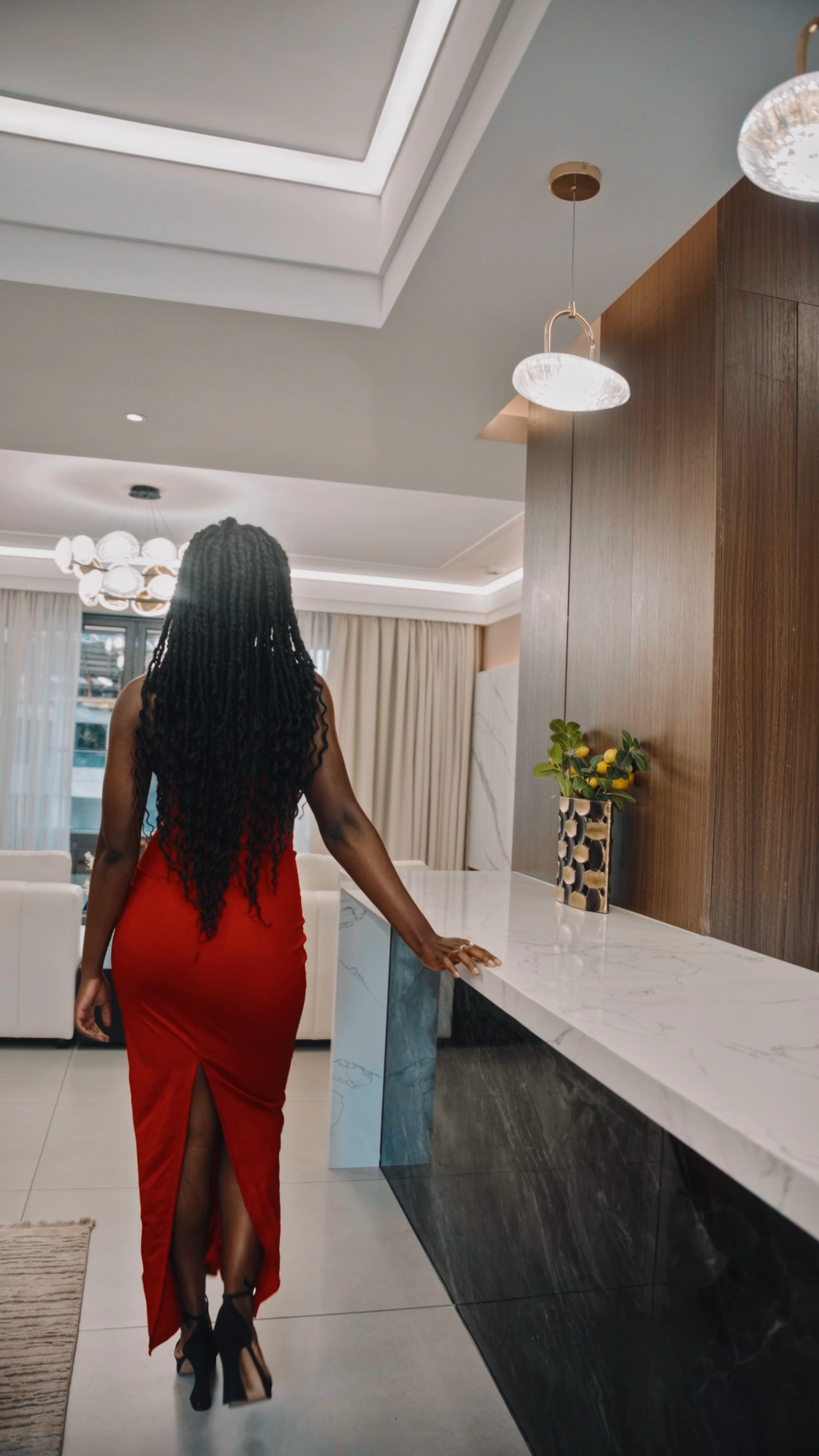Presenter in a red gown at a marble kitchen island