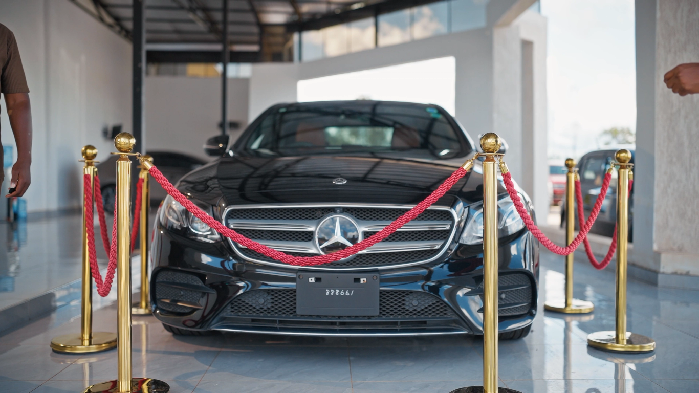 Black Mercedes on display in a showroom with red ropes