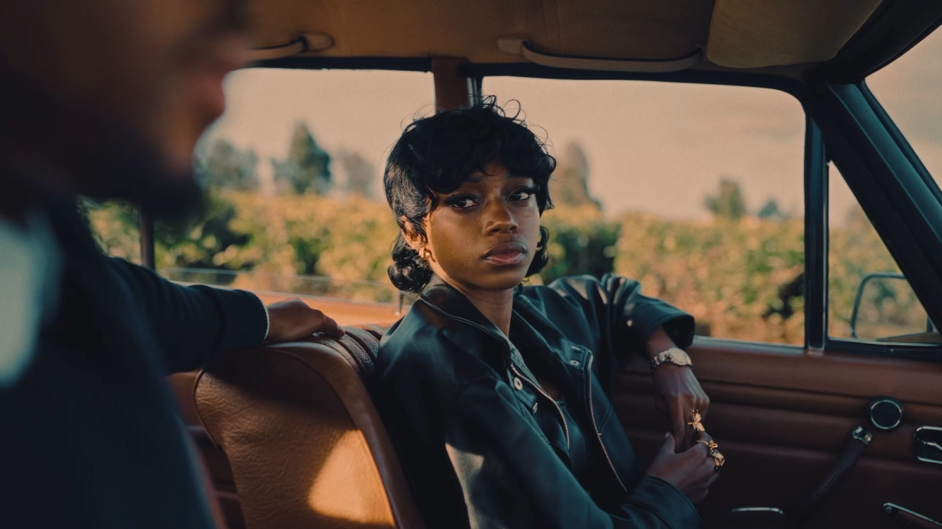 Woman seated inside a vintage car in warm light