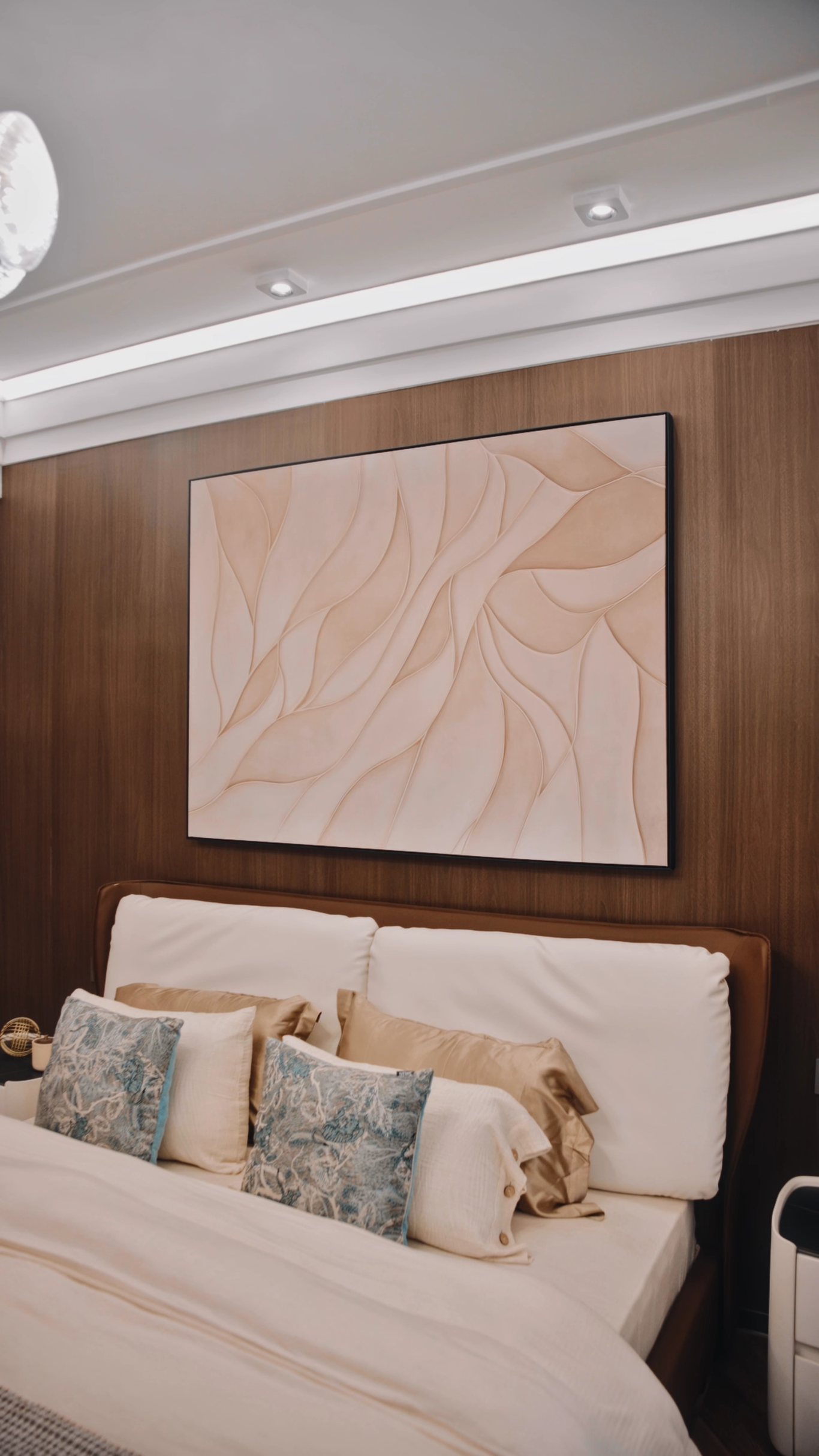 Bedroom with abstract wall art, warm wood panelling and soft bedding