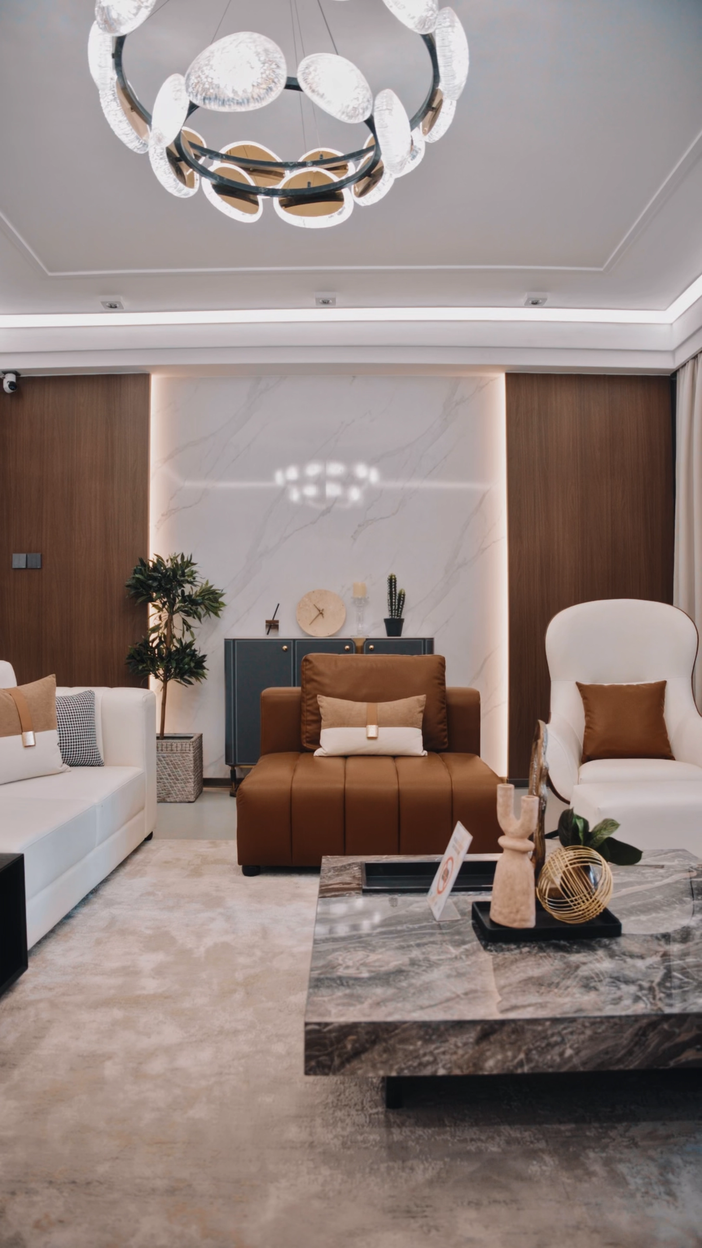 Living room with leather bench seating, a marble coffee table and a sculptural chandelier