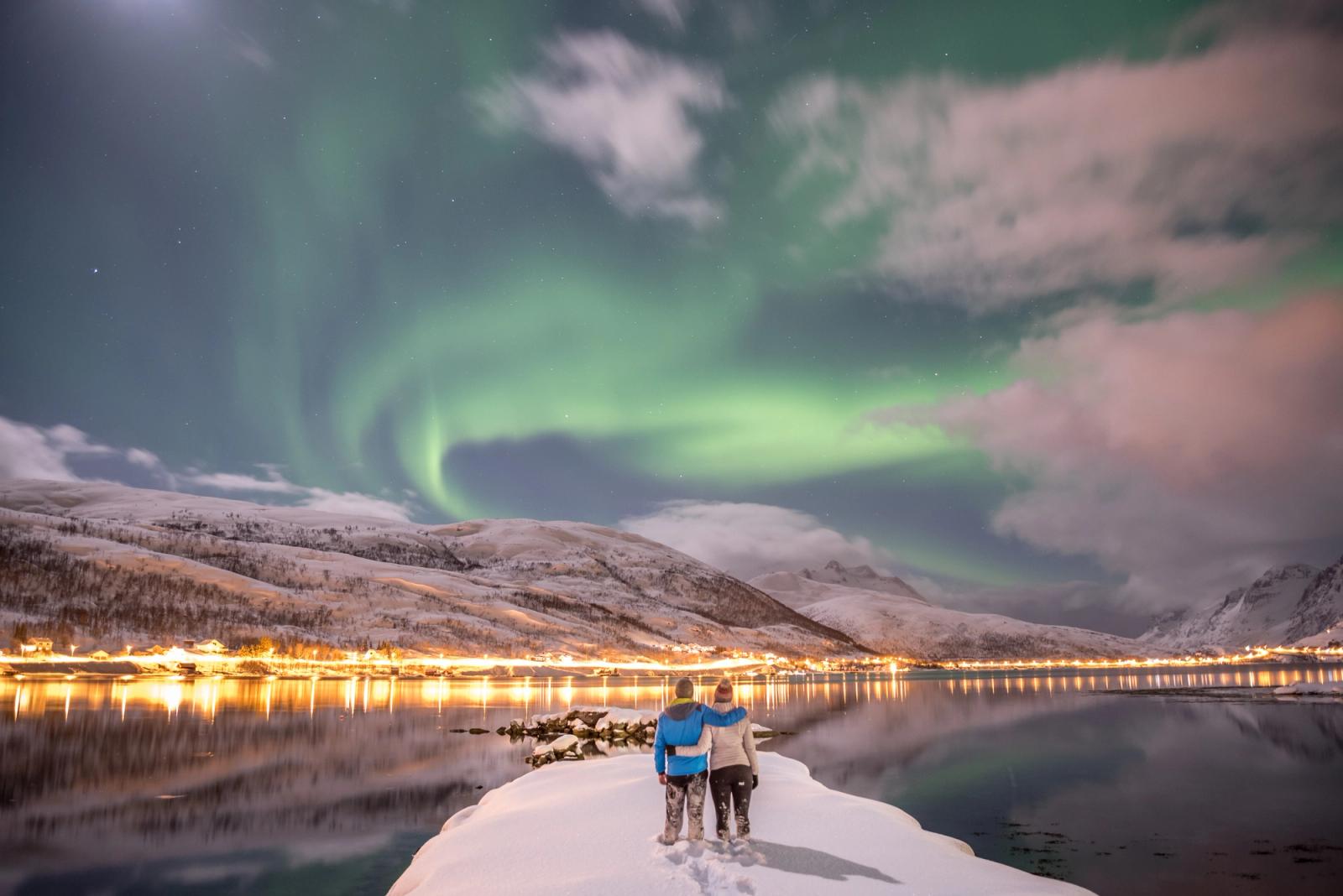 coppia abbracciata mentre guarda l aurora boreale