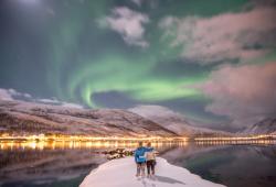 coppia abbracciata mentre guarda l aurora boreale