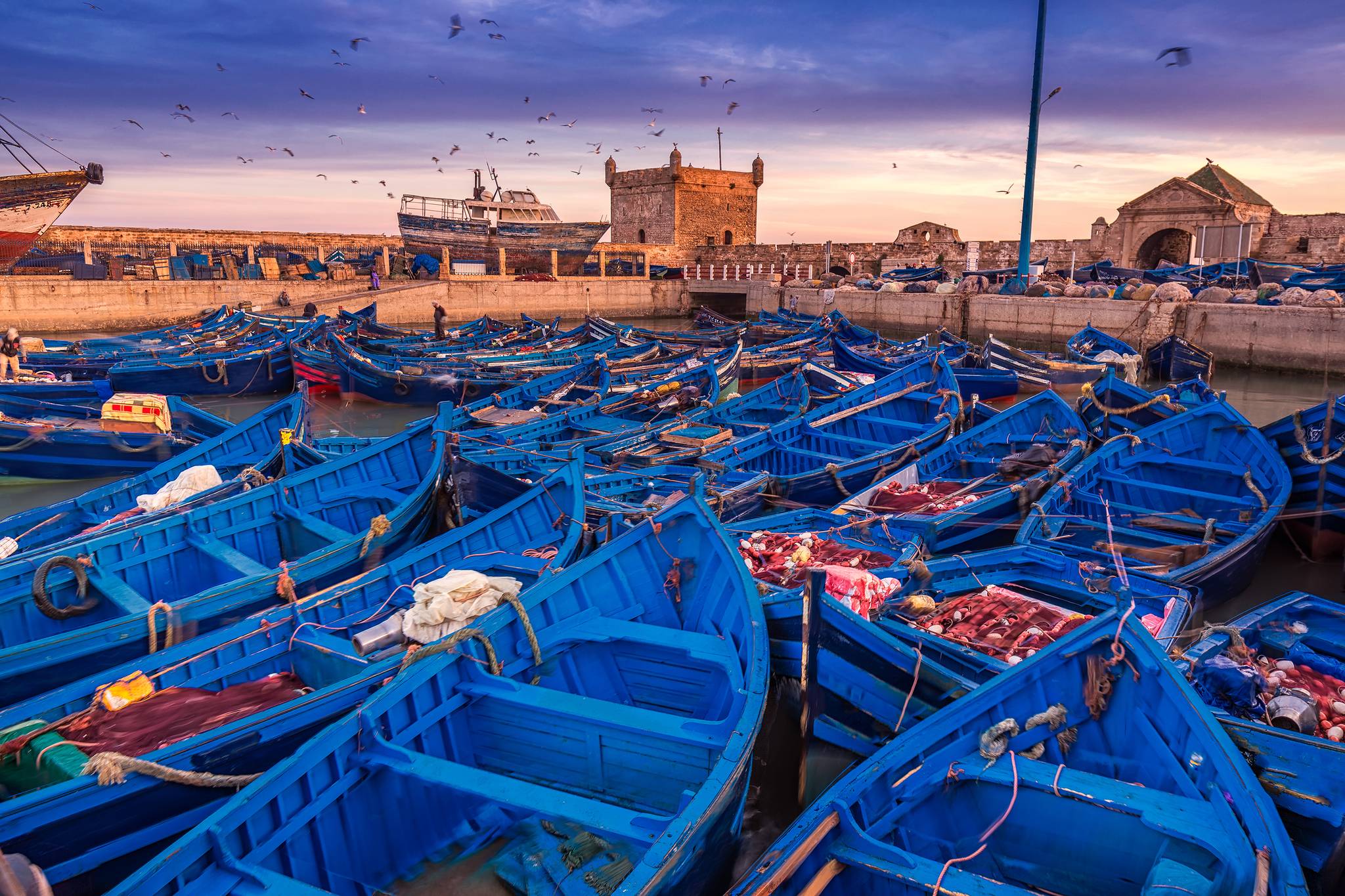 boats moored at the port of Essaouira at sunset