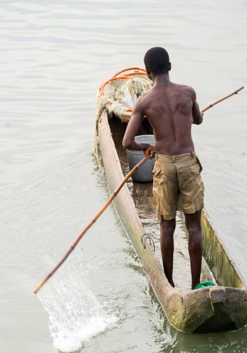 uomo su barca tradizionale su fiume in costa d avorio