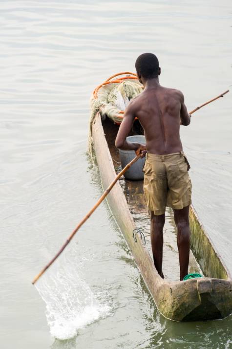uomo su barca tradizionale su fiume in costa d avorio