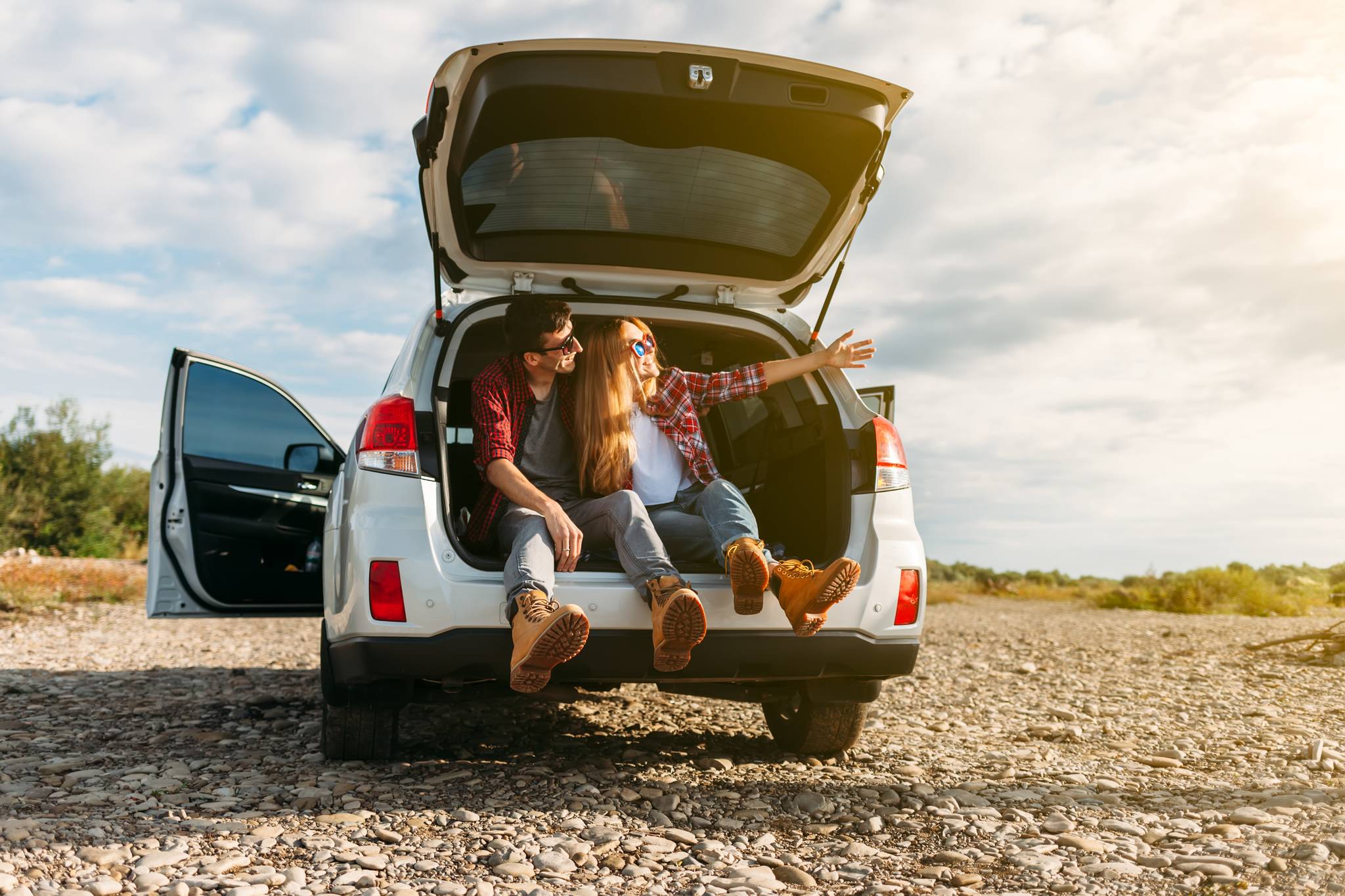 uomo e donna viaggio in macchina al tramonto