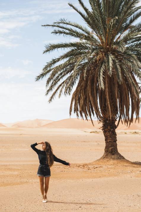 ragazza in un oasi con palma in algeria