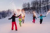 persone in festa con fiaccole sulla neve