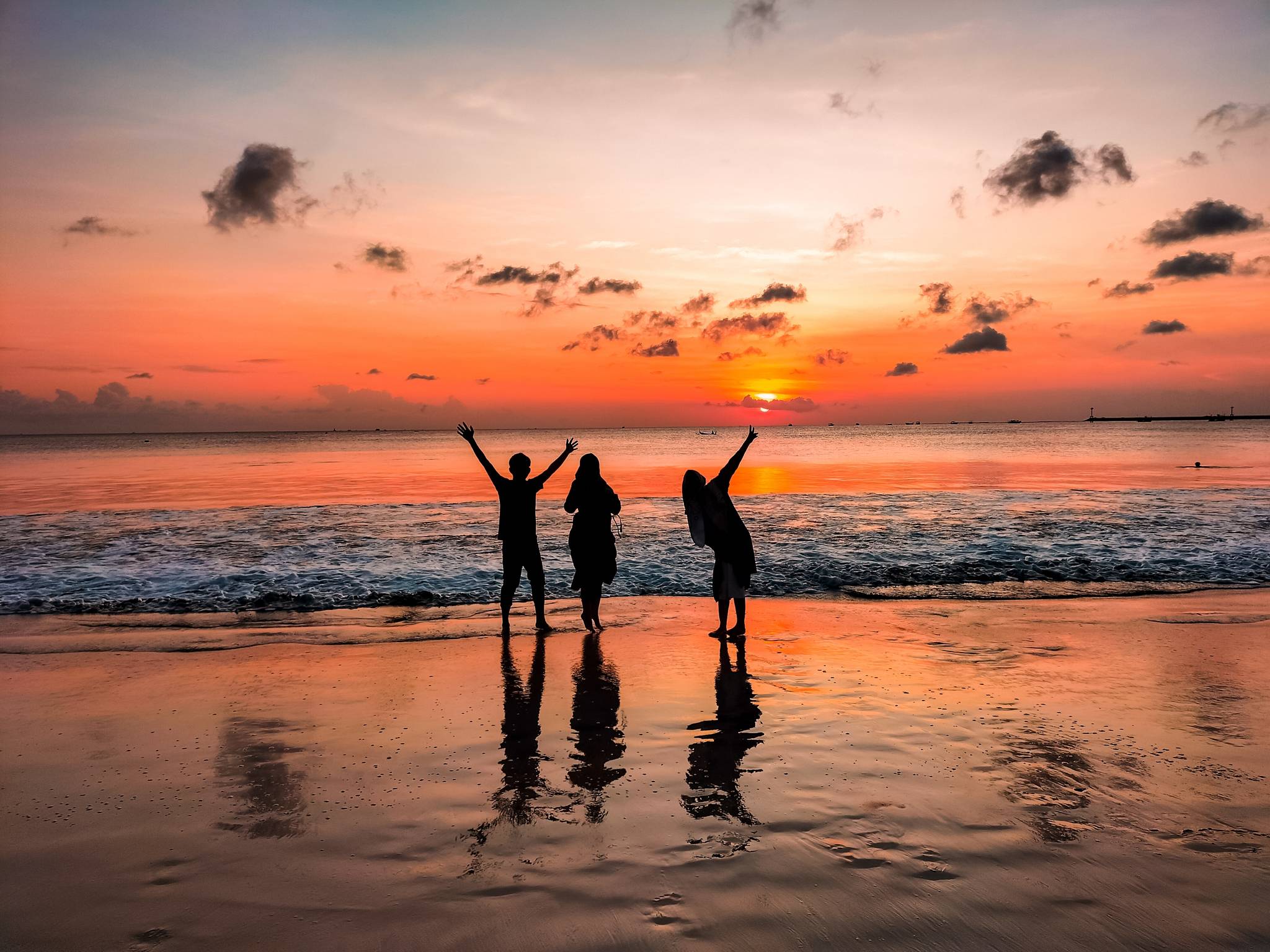 ragazzi di spalle al mare al tramonto