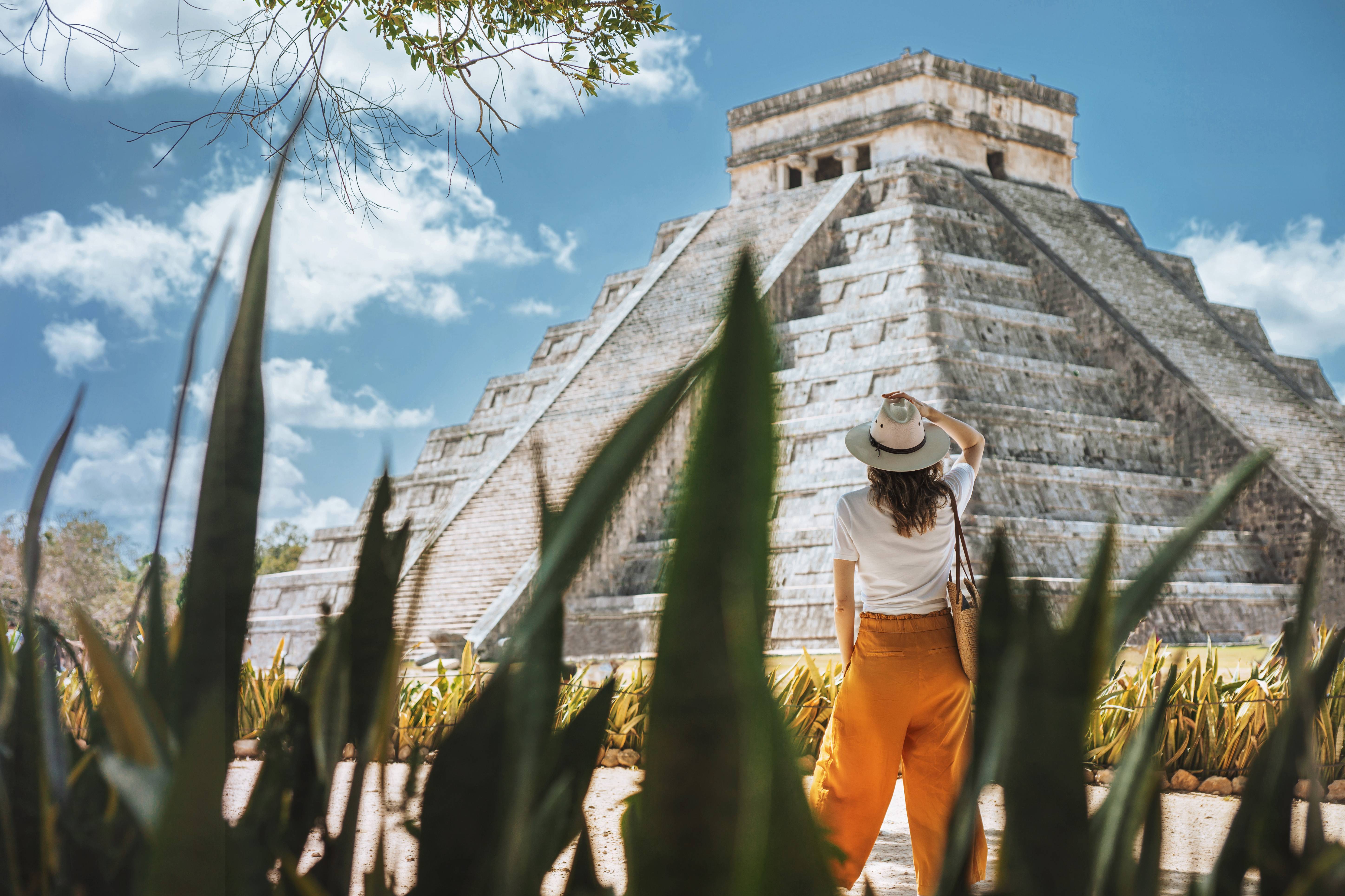 donna davanti a tempio maya tra le foglie