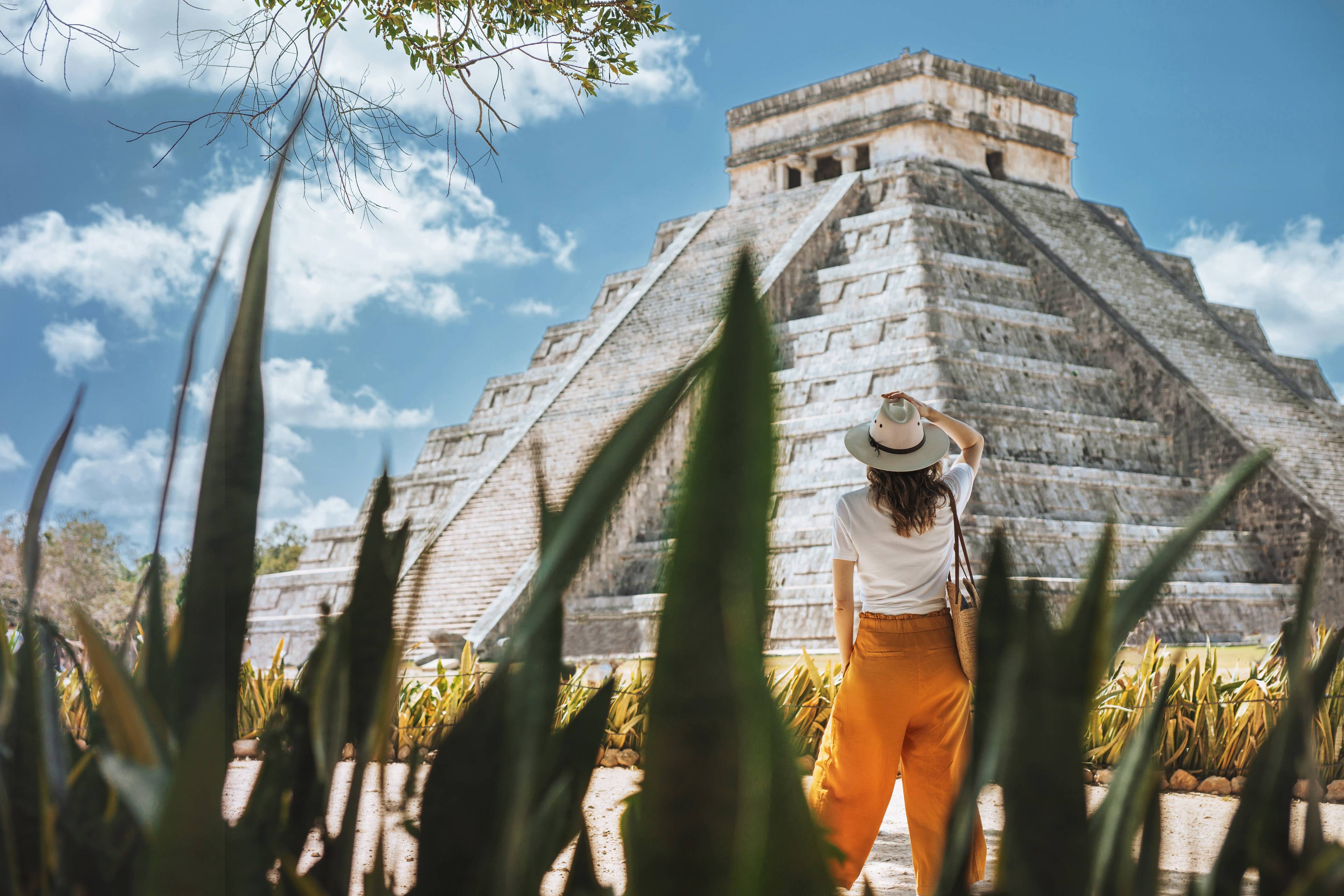 donna davanti a tempio maya tra le foglie