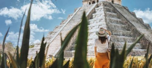 donna davanti a tempio maya tra le foglie