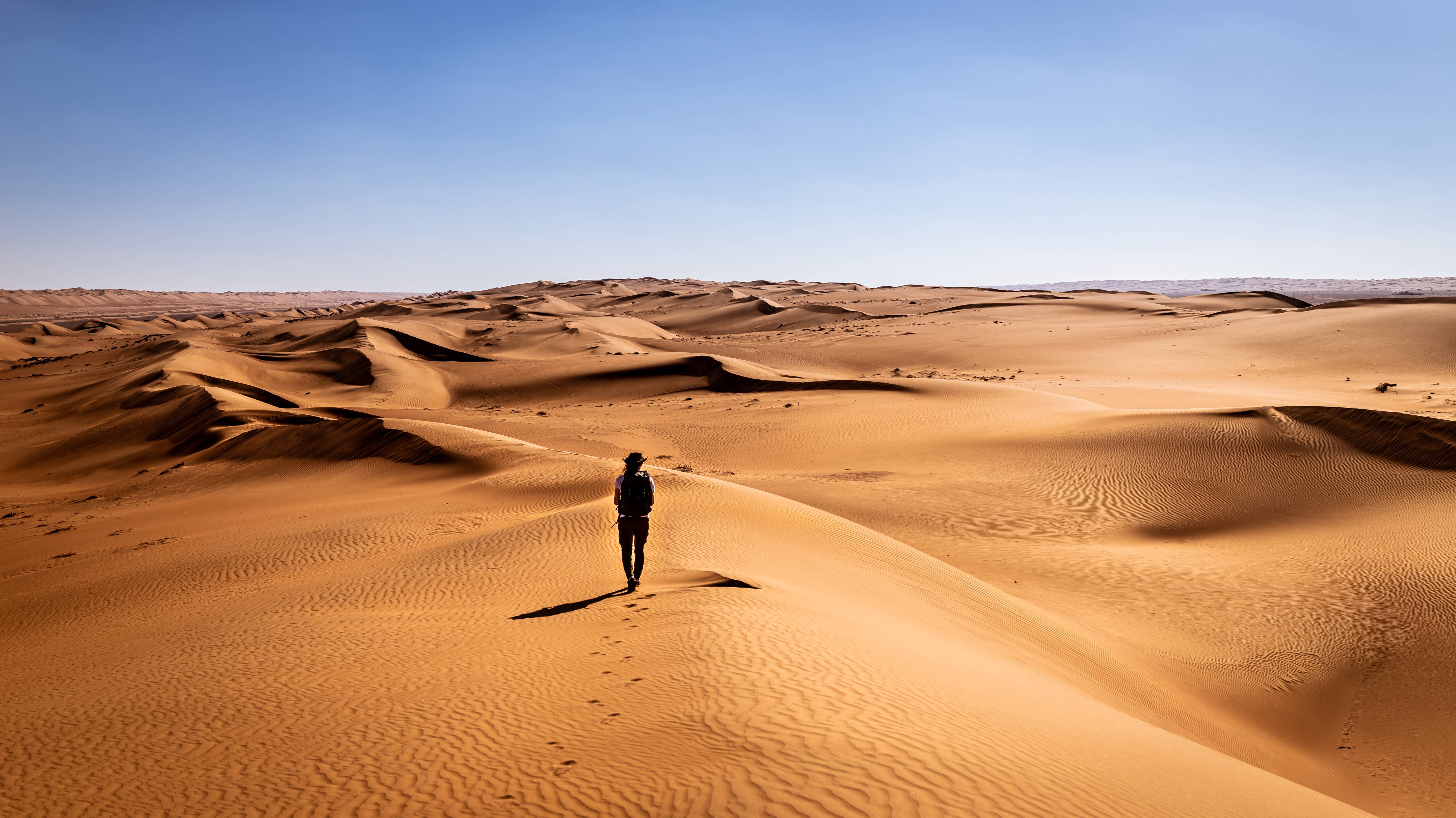 uomo cammina nel deserto wahiba sands