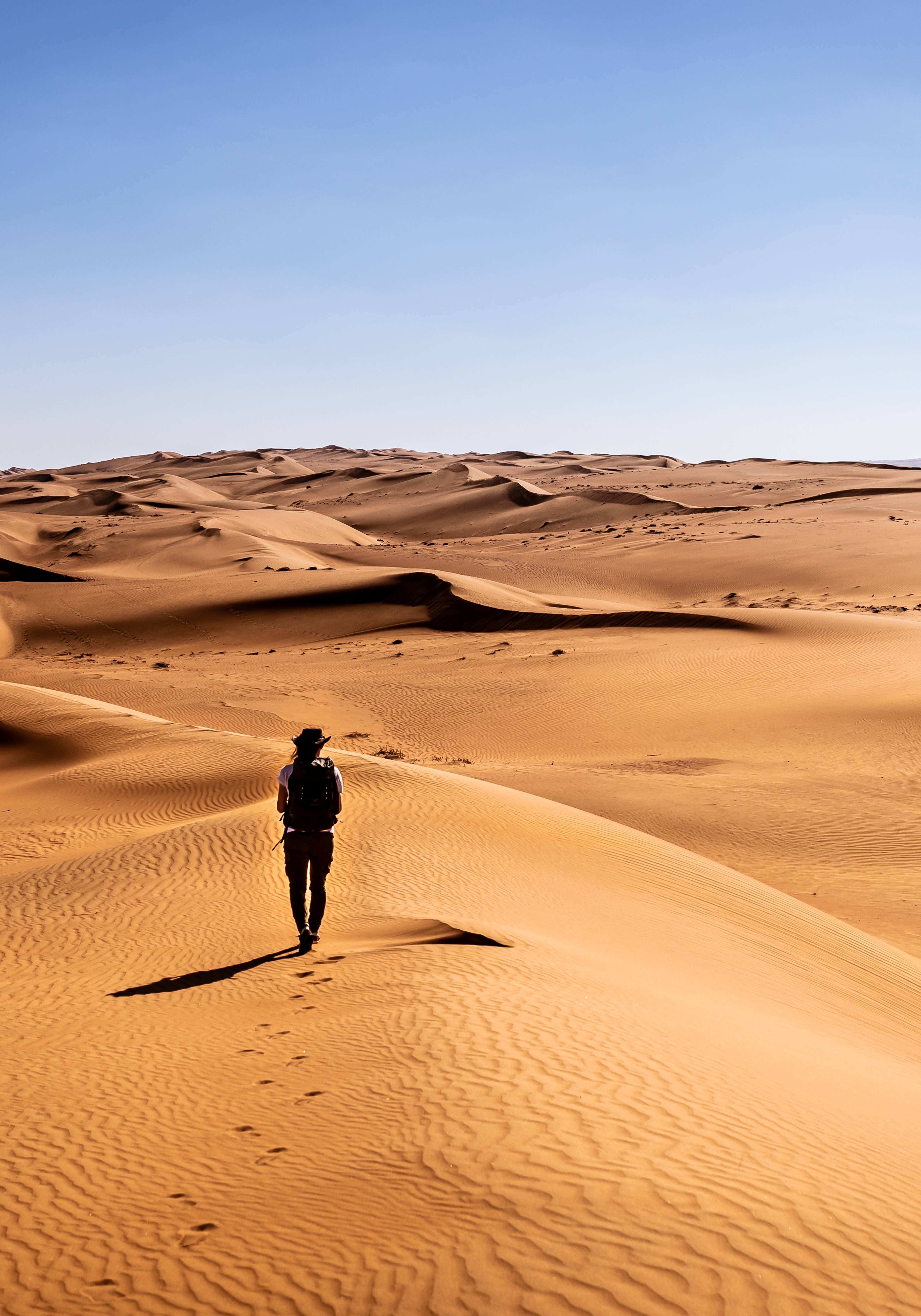 uomo cammina nel deserto wahiba sands