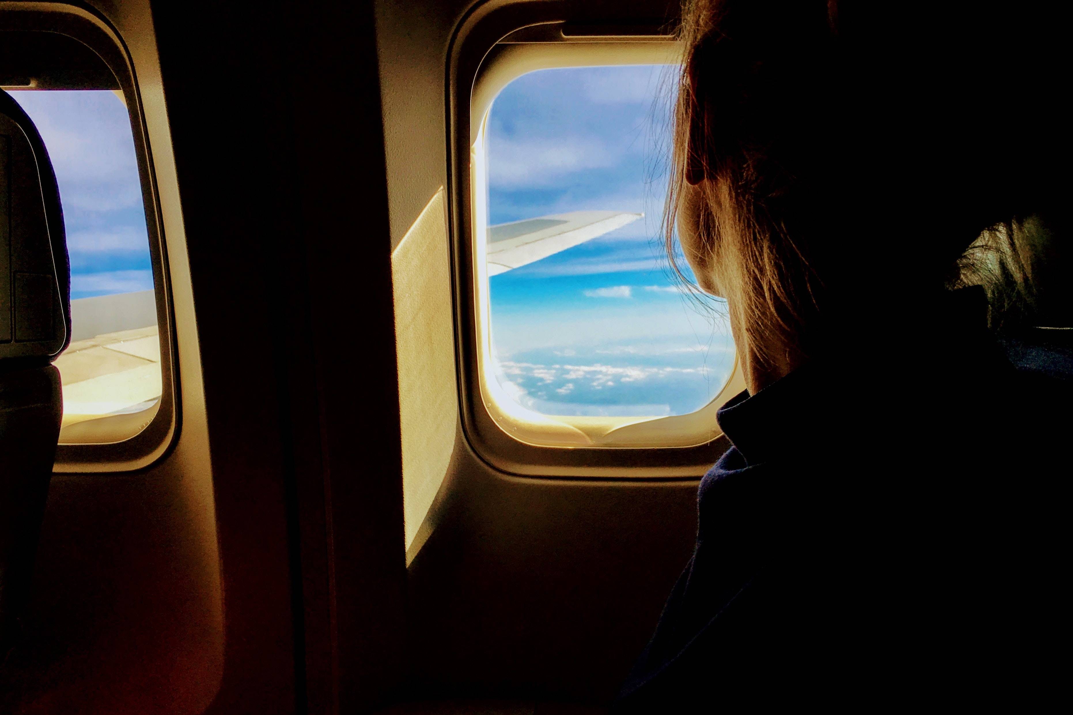 ragazza che guarda al finestrino di un aereo